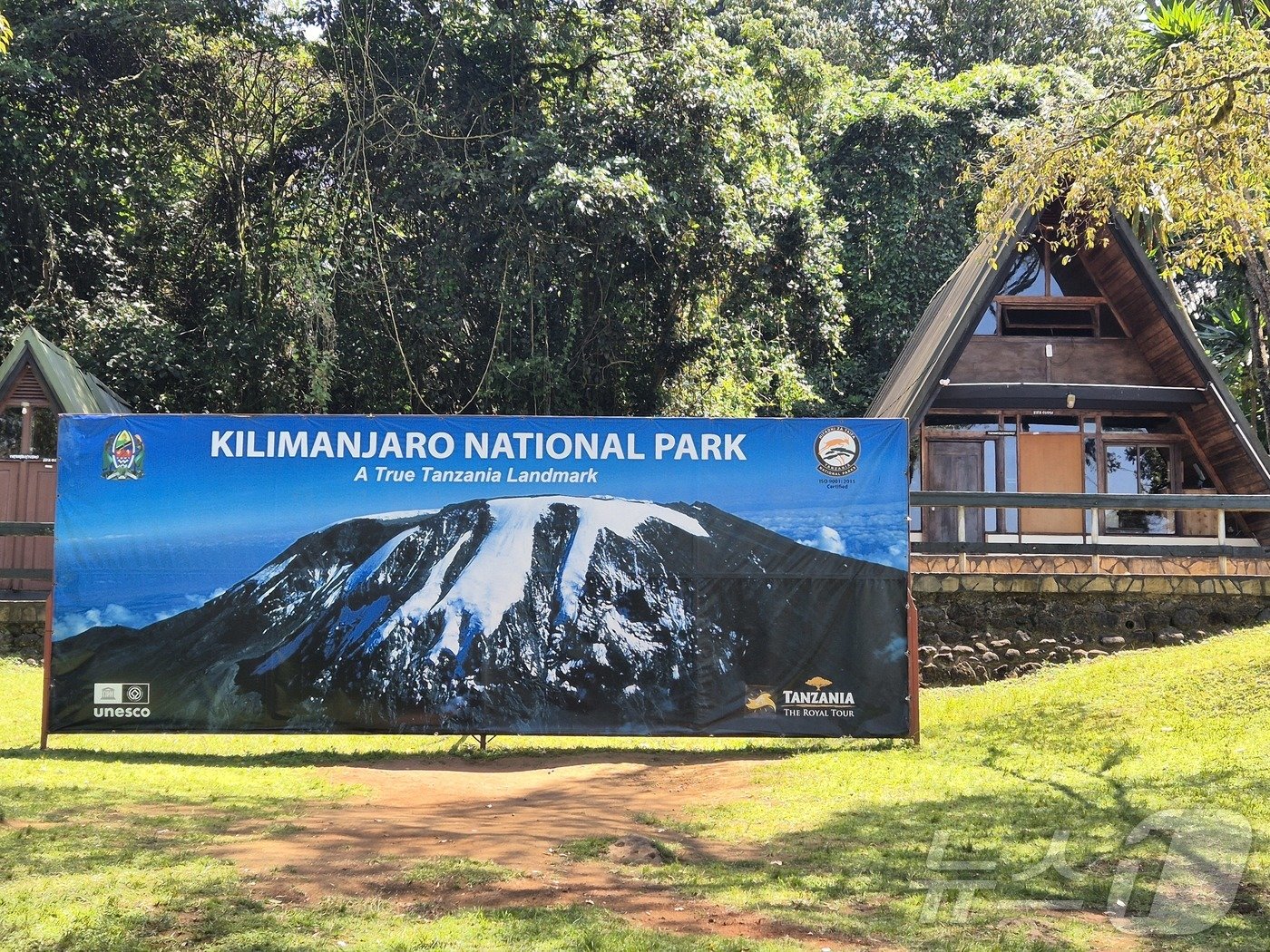 본문 이미지 - 등정의 출발점이자 원점회귀 지점인 마랑구 게이트의 킬리만자로 국립공원 사진 광고판.2024.10.4./뉴스1 ⓒ News1 조영석 기자 
