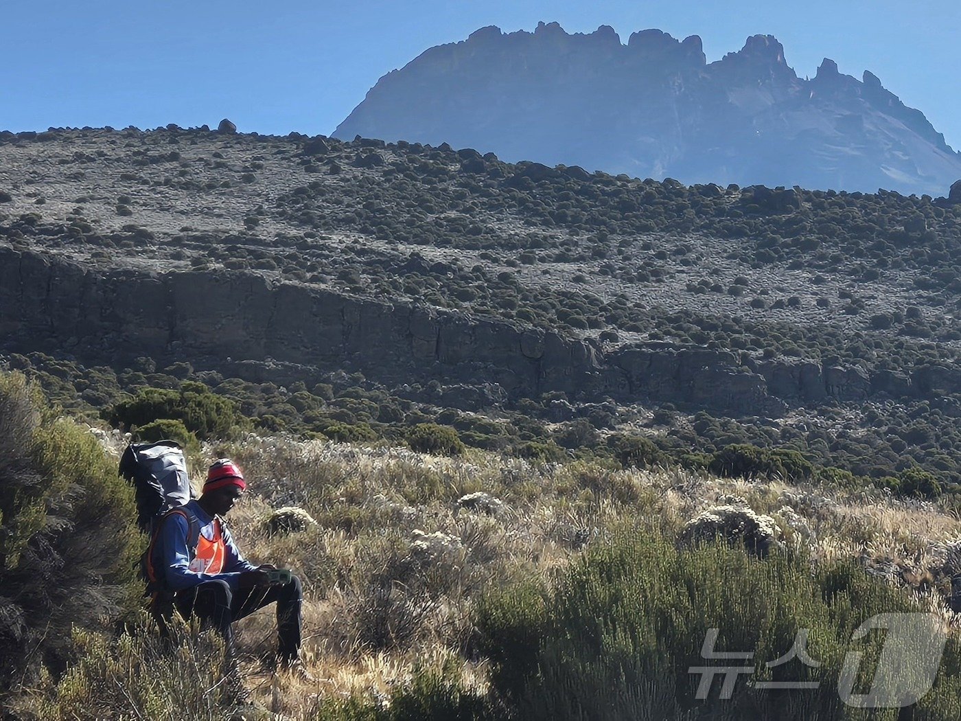 본문 이미지 - 소년 포터. 어린 소년이 짐을 내려놓고 마웬지 봉을 바라보며 가쁜 숨을 달래고 있다. 본인의 배낭과 여행객의 2명의 짐을 지고 우후루 피크까지 올라야 한다.2024.10.8./뉴스1 ⓒ News1 조영석 기자