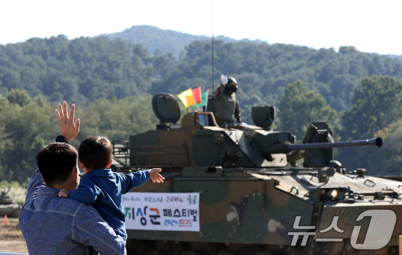 (계룡=뉴스1) 김기태 기자 = 2일 충남 계룡대 활주로에서 열린 2024 계룡군문화축제·지상군페스티벌에서 관람객이 기갑기동 시범에 손인사를 하고 있다. 2024.10.2/뉴스1