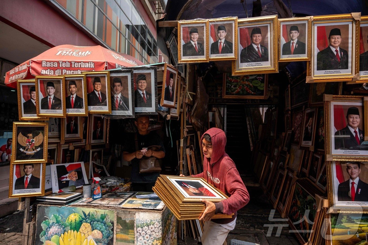 본문 이미지 - 20일(현지시간) 프라보워 수비안토 인도네시아 신임 대통령의 취임식이 치러지는 가운데 자카르타의 한 상점에서 수비안토 대통령의 사진을 걸어뒀다. 24.10.20 ⓒ AFP=뉴스1 ⓒ News1 김예슬 기자