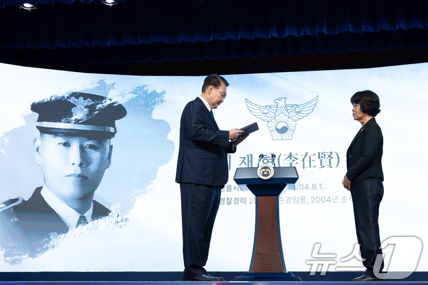 본문 이미지 - 윤석열 대통령이 21일 서울 서대문구 경찰청 참수리홀에서 열린 79주년 경찰의 날 기념식에서 故 이재현 경장의 모친 유진숙 씨에게 '경찰 영웅패'를 전달하고 있다. (대통령실 제공) 2024.10.21/뉴스1 ⓒ News1 송원영 기자