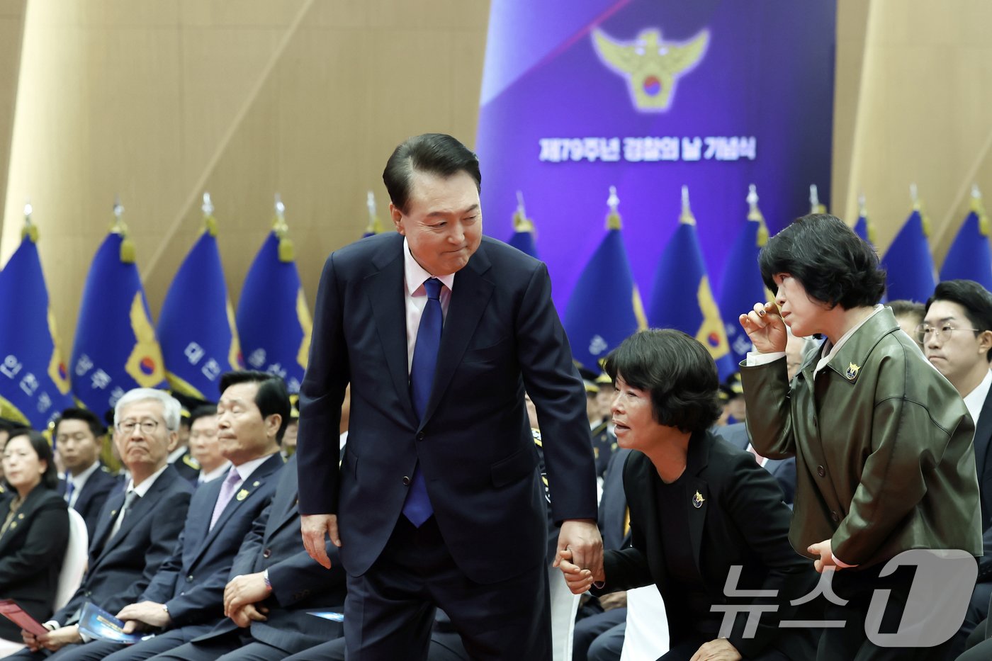 본문 이미지 - 윤석열 대통령이 21일 서울 서대문구 경찰청 참수리홀에서 열린 79주년 경찰의 날 기념식에서 '경찰 영웅패' 전달을 위해 故 이재현 경장의 모친 유진숙 씨, 故 심재호 경위의 배우자 황옥주 씨와 단상으로 향하고 있다. (대통령실 제공) 2024.10.21/뉴스1 ⓒ News1 송원영 기자