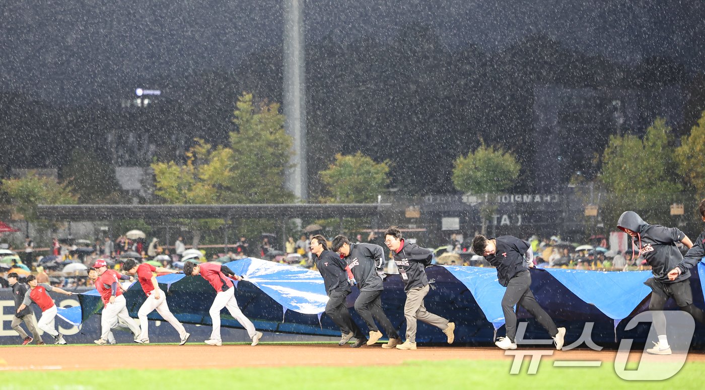 21일 오후 광주 북구 기아챔피언스필드에서 열리는 프로야구 &#39;2024 신한 SOL 뱅크 KBO 포스트시즌&#39; 한국시리즈 1차전 삼성 라이온즈와 기아 타이거즈의 경기에 앞서 비가오자 관계자들이 경기장에 방수포를 덮고 있다. 2024.10.21/뉴스1 ⓒ News1 김도우 기자