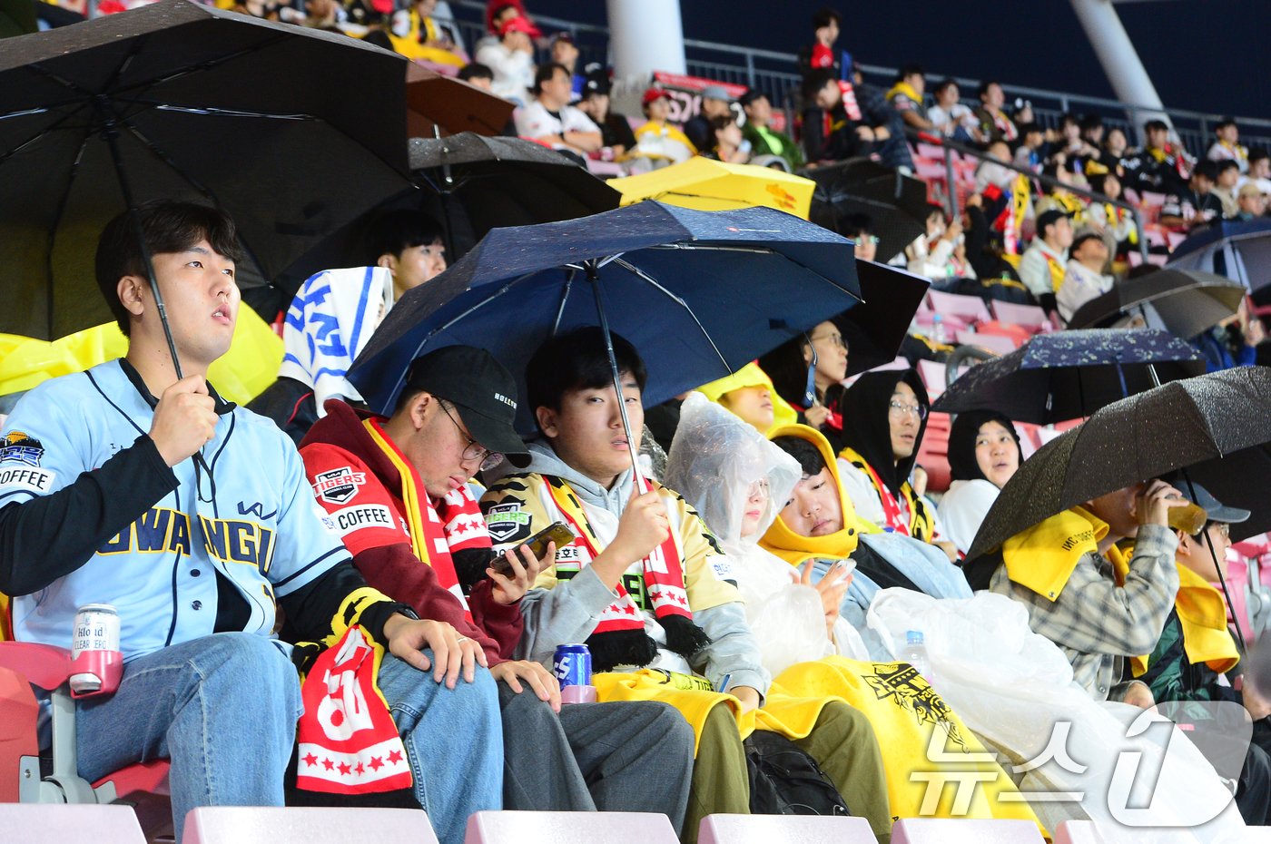 본문 이미지 - 2024 신한 SOL뱅크 KBO 포스트시즌 KS(한국시리즈) 1차전, 삼성라이온즈와 KIA 타이거즈의 경기가 열리는 21일 오후 광주기아챔피언스필드에서 야구팬들이 우산과 우비를 쓴 채 경기를 기다리고 있다. 2024.10.21/뉴스1 ⓒ News1 이승현 기자