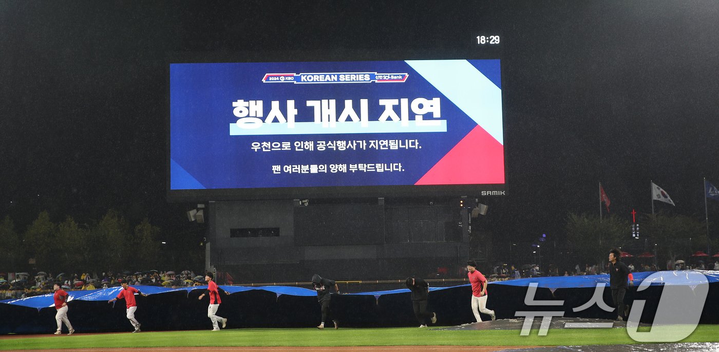 21일 오후 광주 북구 기아챔피언스필드에서 열리는 프로야구 &#39;2024 신한 SOL 뱅크 KBO 포스트시즌&#39; 한국시리즈 1차전 삼성 라이온즈와 기아 타이거즈의 경기에 앞서 비가오자 관계자들이 경기장에 방수포를 덮고 있다. 2024.10.21/뉴스1 ⓒ News1 임세영 기자