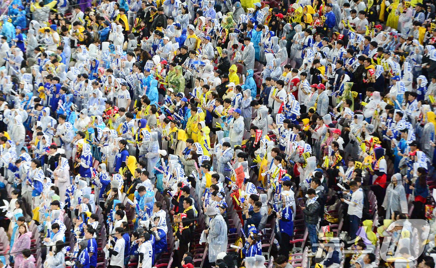 본문 이미지 - 2024 신한 SOL뱅크 KBO 포스트시즌 KS 1차전, 삼성라이온스와 KIA 타이거즈의 경기가 열리는 21일 오후 광주기아챔피언스필드에서 야구팬들이 우비를 쓴 채 경기 응원을 하고 있다. 2024.10.21/뉴스1 ⓒ News1 이승현 기자