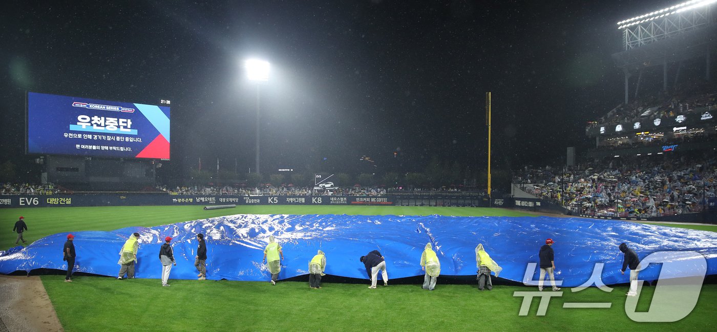 21일 오후 광주 기아챔피언스필드에서 열린 프로야구 &#39;2024 신한 SOL 뱅크 KBO 포스트시즌&#39; 한국시리즈 1차전 삼성 라이온즈와 KIA 타이거즈의 경기, 6회초 무사 1,2루 상황 우천으로 경기가 중단되자 관계자들이 그라운드에 방수포를 덮고있다. 2024.10.21/뉴스1 ⓒ News1 임세영 기자