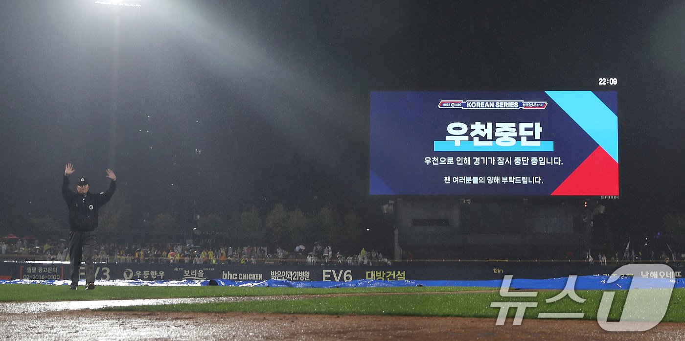 본문 이미지 - 21일 오후 광주 기아챔피언스필드에서 열린 프로야구 '2024 신한 SOL 뱅크 KBO 포스트시즌' 한국시리즈 1차전 삼성 라이온즈와 KIA 타이거즈의 경기 6회초 무사 1,2루 상황 심판이 우천으로 서스펜디드 게임이 선언하고 있다. 2024.10.21/뉴스1 ⓒ News1 임세영 기자