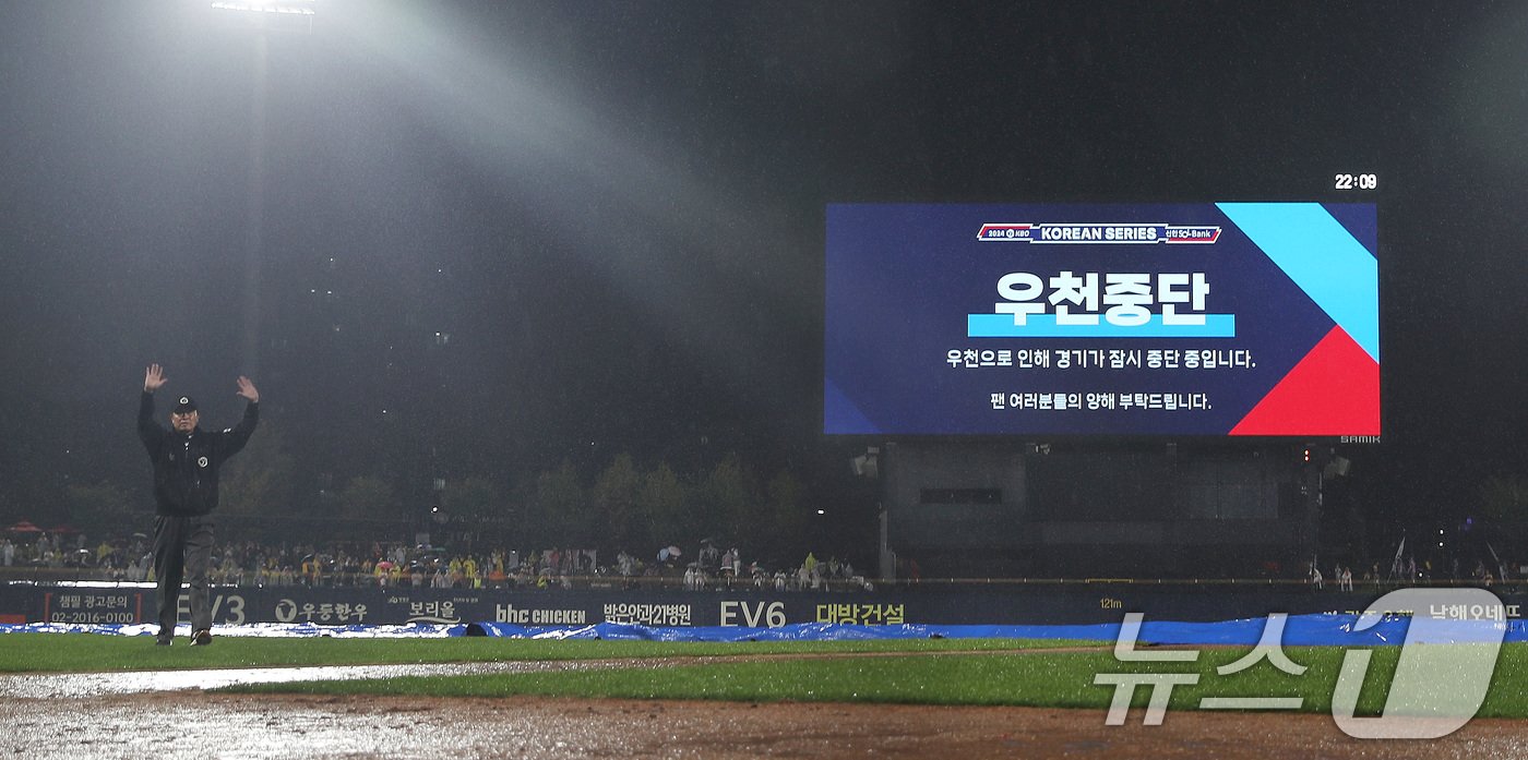 21일 오후 광주 기아챔피언스필드에서 열린 프로야구 &#39;2024 신한 SOL 뱅크 KBO 포스트시즌&#39; 한국시리즈 1차전 삼성 라이온즈와 KIA 타이거즈의 경기 6회초 무사 1,2루 상황 심판이 우천으로 서스펜디드 게임이 선언하고 있다. 2024.10.21/뉴스1 ⓒ News1 임세영 기자