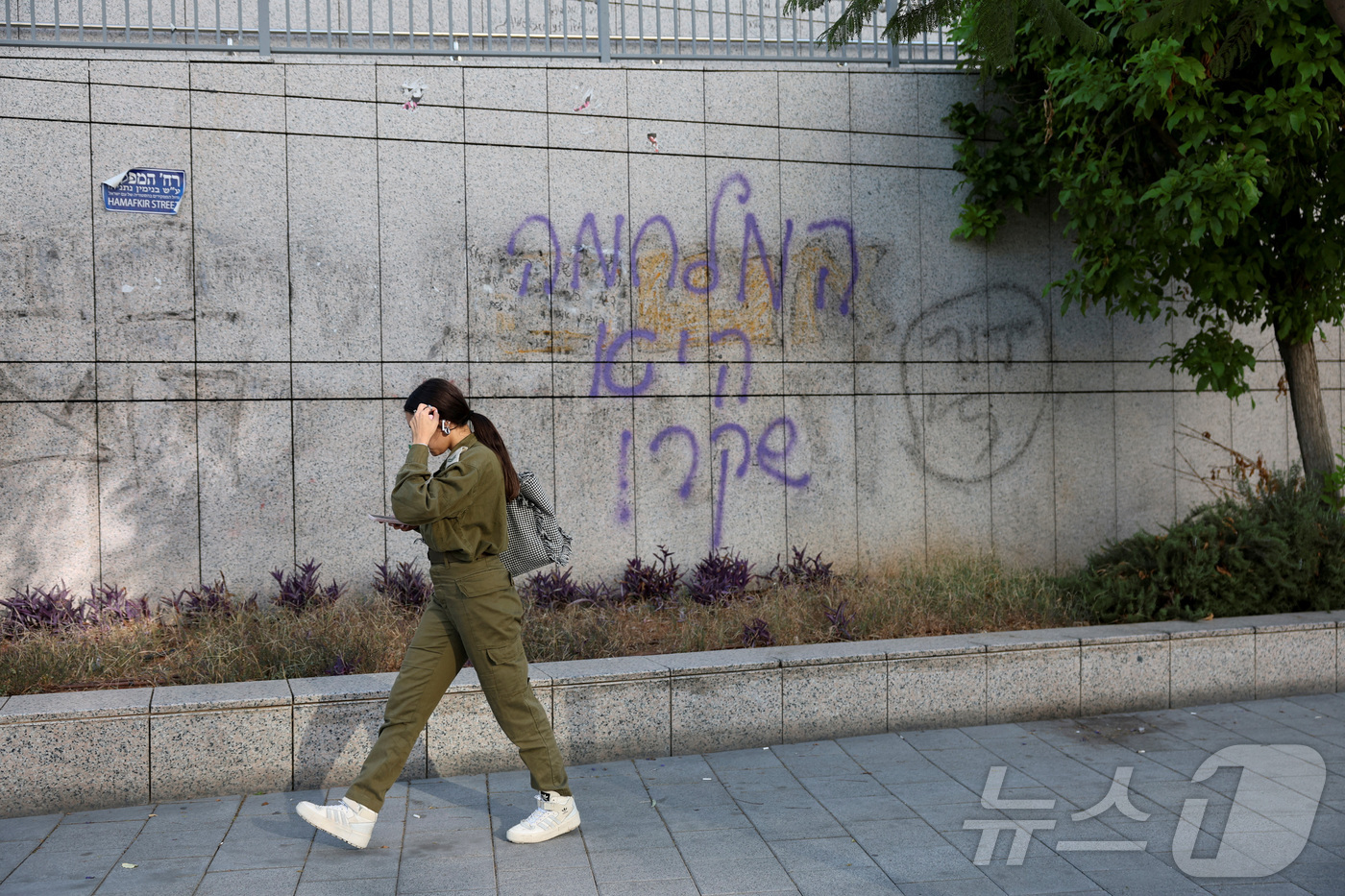 (텔아비브 로이터=뉴스1) 김지완 기자 = 20일 이스라엘 텔아비브의 국방부 청사의 "전쟁은 거짓말"이라는 낙서가 그려진 담벼락 옆을 한 군인이 지나가고 있다. 2024.10.20 …