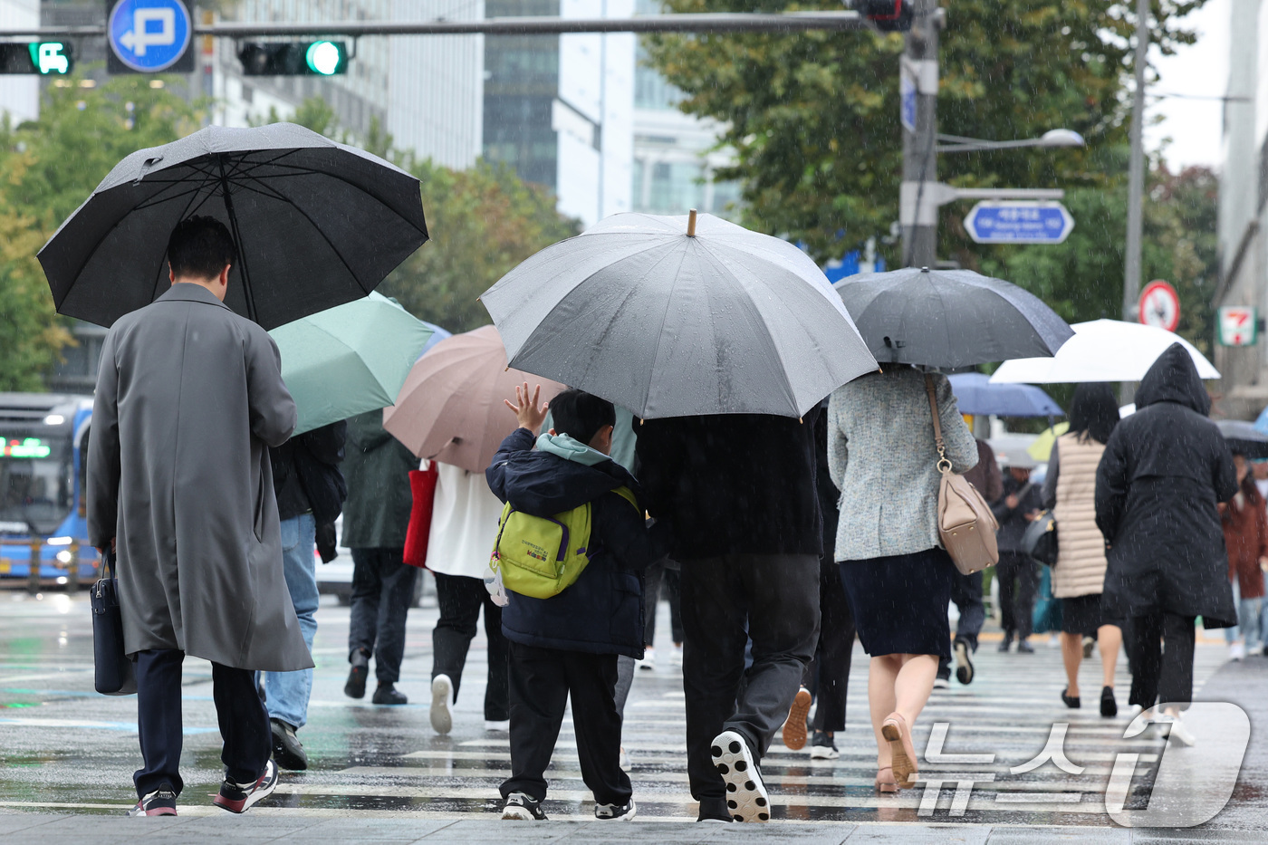 (서울=뉴스1) 신웅수 기자 = 전국적으로 가을비가 내린 22일 서울 광화문네거리에서 아빠와 함께 우산을 쓴 어린이가 손을 들고 횡단보도를 건너고 있다.기상청은 이날 종일 가을비가 …