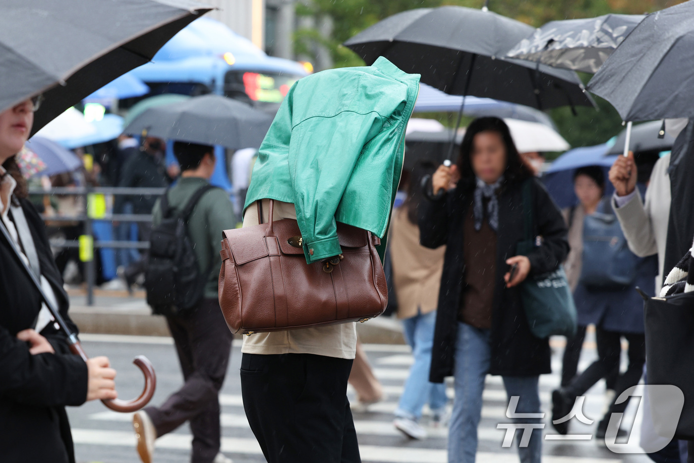 (서울=뉴스1) 신웅수 기자 = 전국적으로 가을비가 내린 22일 서울 광화문네거리에서 우산을 챙기지 못한 시민이 겉옷으로 비를 가리고 있다.기상청은 이날 종일 가을비가 내리면서 선 …