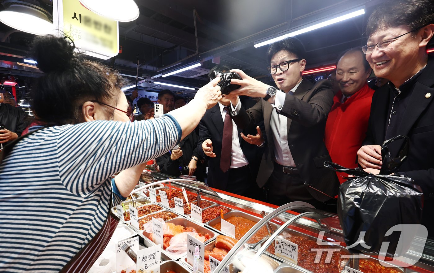 본문 이미지 - 한동훈 국민의힘 대표가 22일 인천 강화풍물시장을 방문, 박용철 강화군수와 함께 상인들에게 당선 감사 인사를 하던 도중 젓갈을 구매하고 있다. 2024.10.22/뉴스1 ⓒ News1 김민지 기자