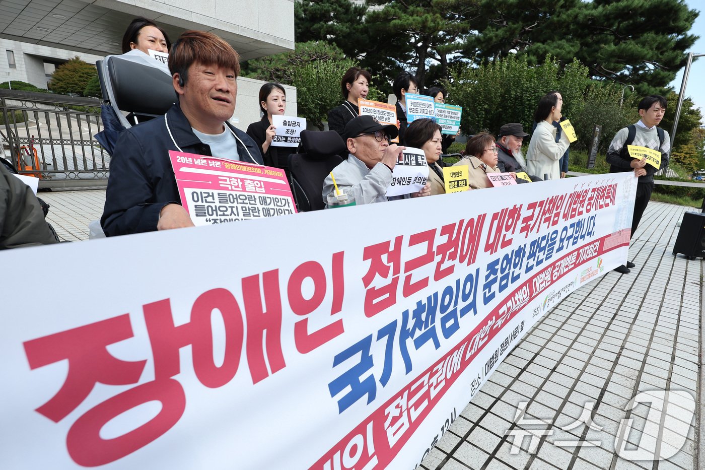 본문 이미지 - 장애인차별금지추진연대 회원들이 23일 오후 서울 서초구 대법원 앞에서 장애인 접근권에 대한 대법원 공개변론 기자회견을 하고 있다. 대법원 전원합의체는 이날 20년 가까이 지체장애인을 위한 편의시설을 설치해야 하는 기준을 개정하지 않아 장애인 접근권이 제대로 보장되지 않았는지 판단하기 위한 공개 변론을 연다. 장애인단체는 이와 관련해 장애인차별금지법이 시행된지 15년이 지났지만 여전히 장애인이 식당이나 편의점 등 기본적인 생활편의시설조차 접근하기 힘든 상황이라고 주장했다. 2024.10.23/뉴스1 ⓒ News1 신웅수 기자
