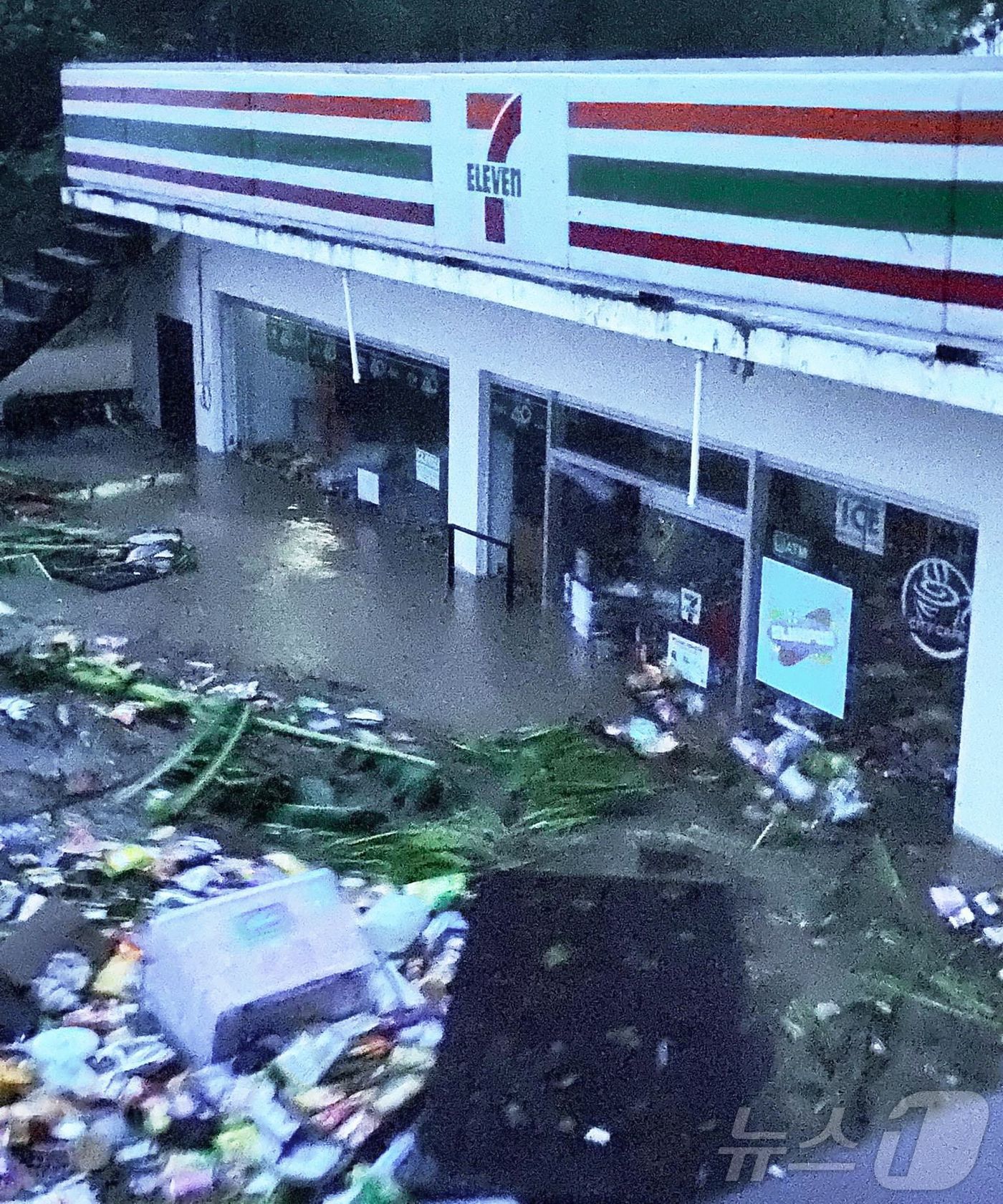 (바토 AFP=뉴스1) 권진영 기자 = 필리핀 바토에서 한 편의점이 태풍 짜미가 몰고온 폭우와 강풍으로 침수됐다. 가게 안의 물건들이 홍수에 떠내려가고 있다. 2024.10.23/ …