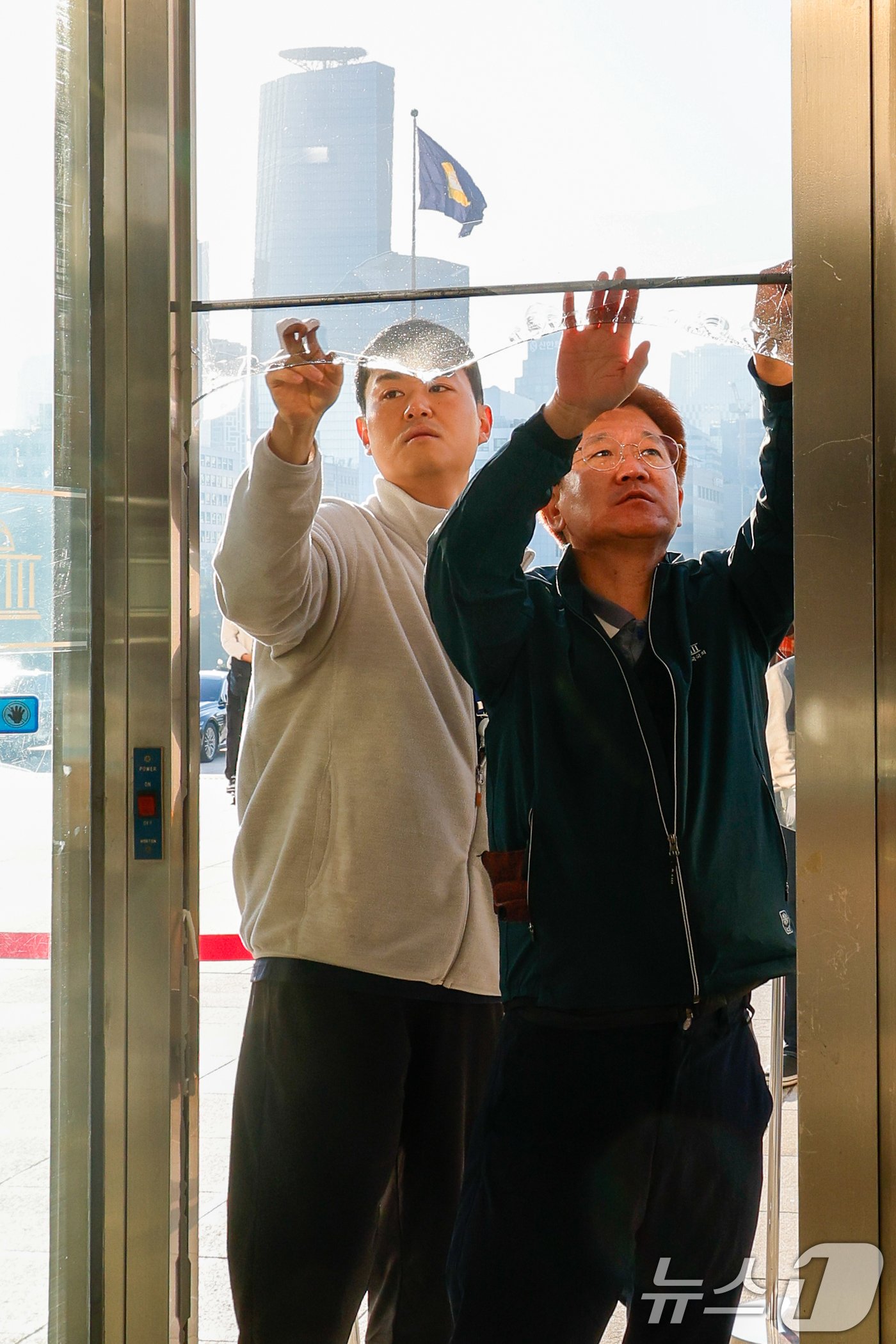 25일 오전 서울 여의도 국회 본관 출입문 유리가 파손돼 관계자들이 이를 수습하고 있다. 이날 오전 5시15분쯤 한 60대 남성이 유리문에 소화기를 던지고 안내 입간판으로 본관 일부를 부숴 경찰에 체포됐다. 2024.10.25/뉴스1 ⓒ News1 안은나 기자