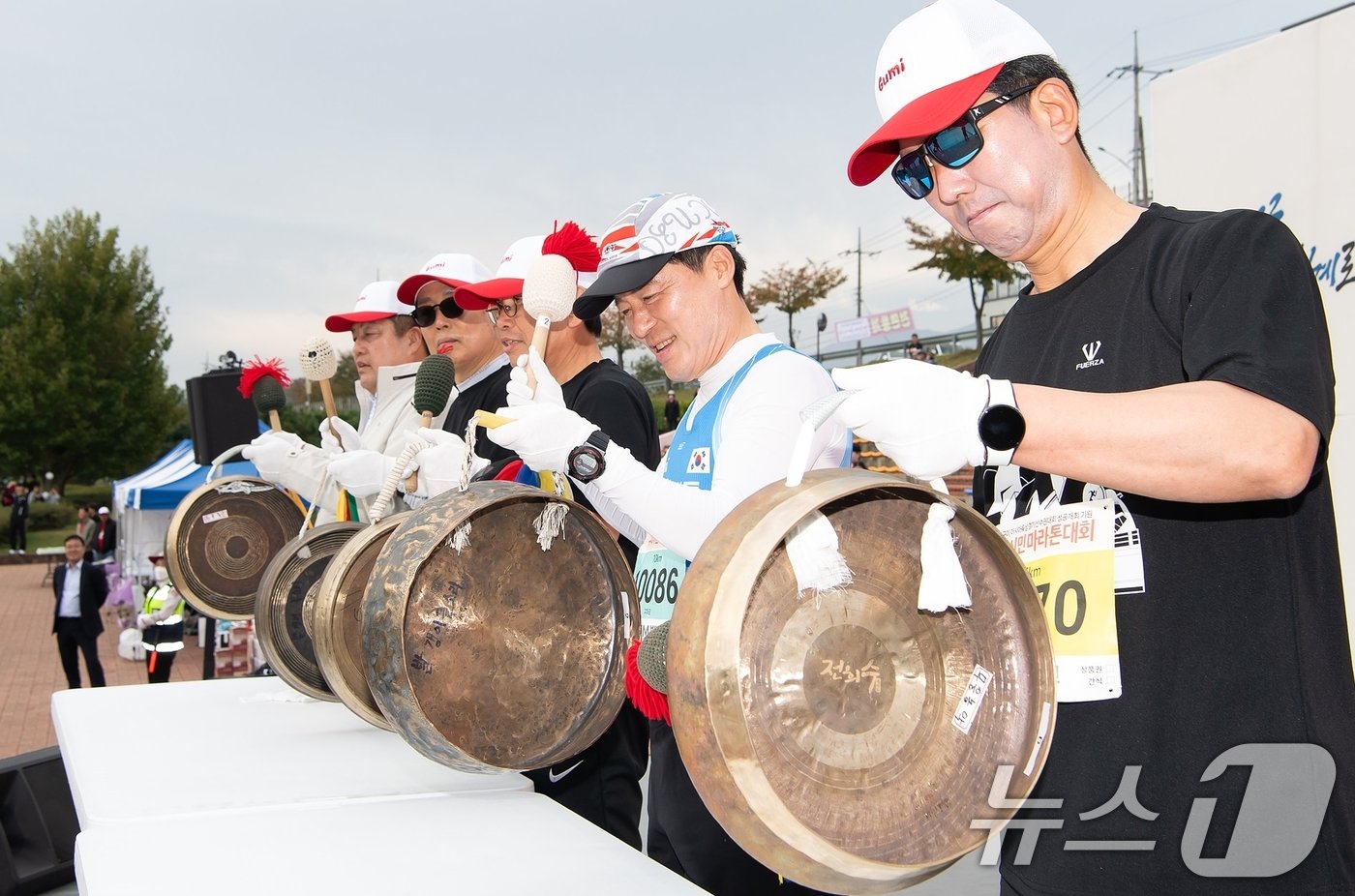 본문 이미지 - 27일 구미낙동강체육공원에서 열린 2024 구미시민마라톤 대회에서 김장호 구미시장과 구자근 의원 등 관계자들이 대회시작을 알리는 징을 치고 있다.(구미시 제공) 2024.10.27/뉴스1