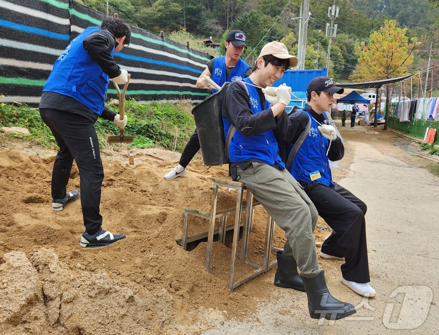 쇼호스트 유인석, 황도영 글로드 대표 등이 운동장 정비를 위한 마사토를 나르고 있다. ⓒ 뉴스1 한송아 기자