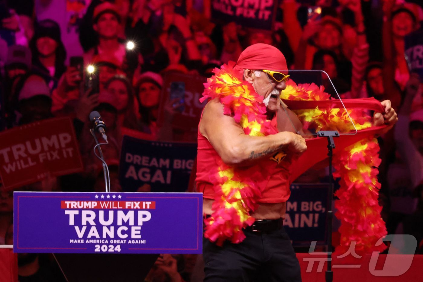 본문 이미지 - 전 프로레슬러 헐크 호건이 27일(현지시간) 뉴욕 매디슨 스퀘어 가든 인근에서 열린 공화당 대선 후보인 도널드 트럼프 전 대통령의 선거 집회에 참석해 셔츠를 찢고 있다. 2024.10.28 ⓒ AFP=뉴스1 ⓒ News1 우동명 기자