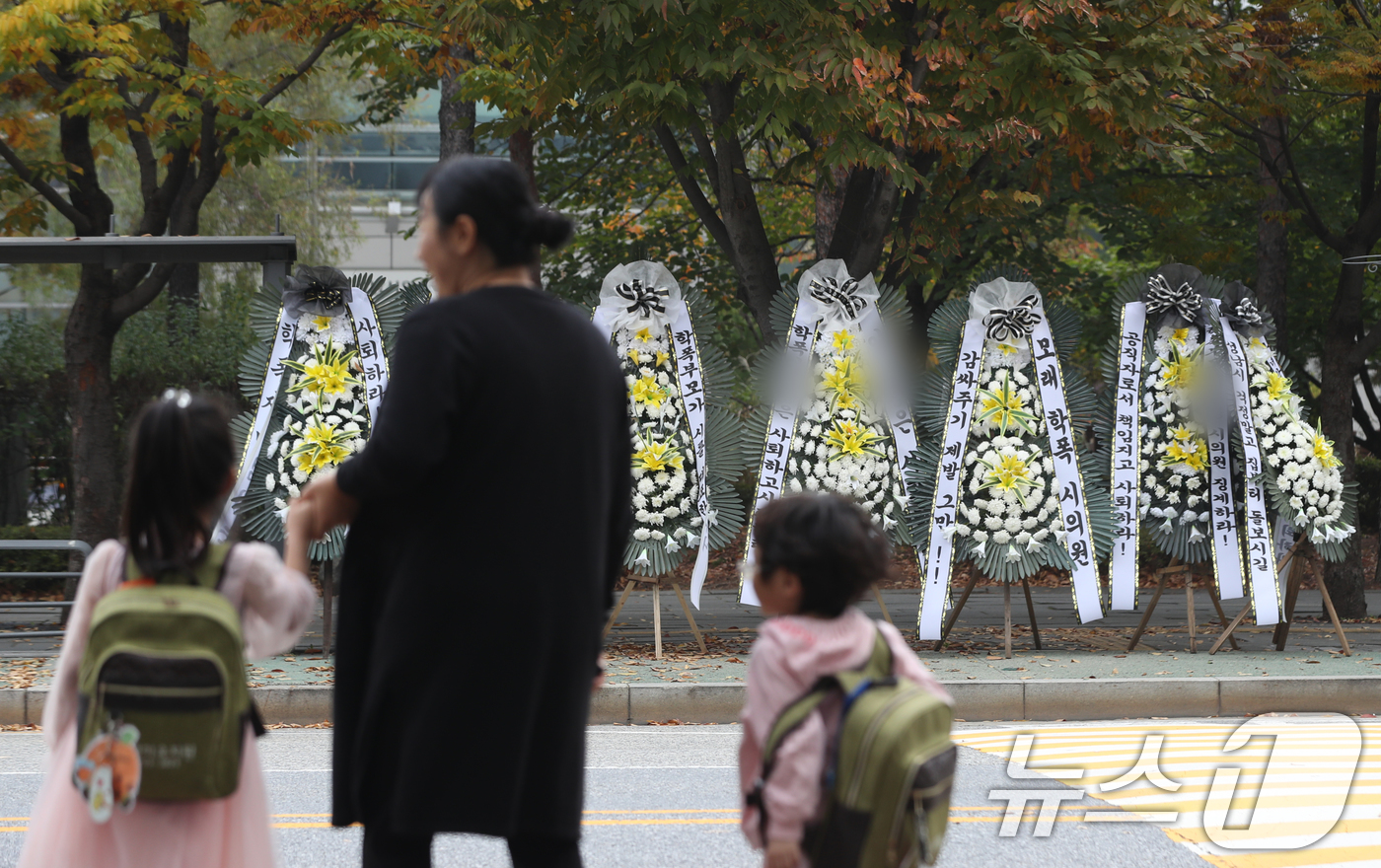 (성남=뉴스1) 김영운 기자 = 28일 오전 경기 성남시 중원구 성남시의회 앞에 A 시의원의 사퇴를 촉구하는 문구가 적인 근조화환이 늘어서 있다.이날 지역 학부모들이 A 시의원 자 …