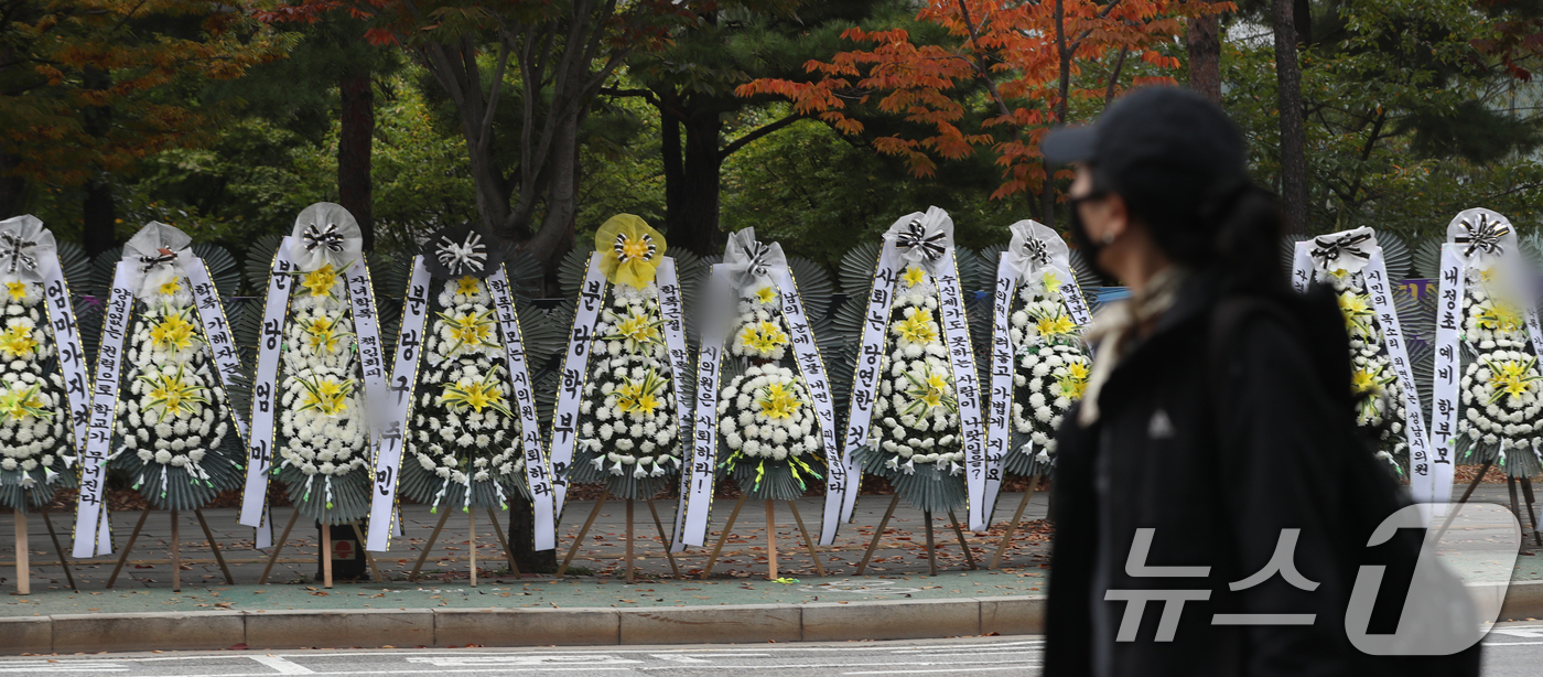 (성남=뉴스1) 김영운 기자 = 28일 오전 경기 성남시 중원구 성남시의회 앞에 A 시의원의 사퇴를 촉구하는 문구가 적인 근조화환이 늘어서 있다.이날 지역 학부모들이 A 시의원 자 …