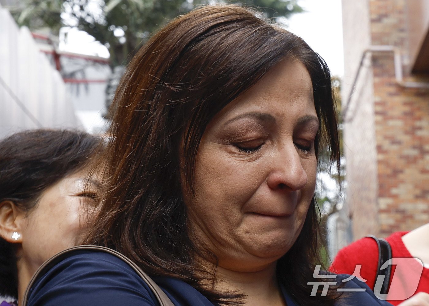 본문 이미지 - 희생자 그레이스 라쉐드의 어머니 조안 라쉐드가 28일 서울 용산구 이태원 참사 골목 '10.29 기억과 안전의길'에서 열린 새로운 10·29 이태원 참사 기억과 안전의 길 빌보드 개막식에서 눈물을 흘리고 있다. (공동취재) 2024.10.28/뉴스1 ⓒ News1 박세연 기자