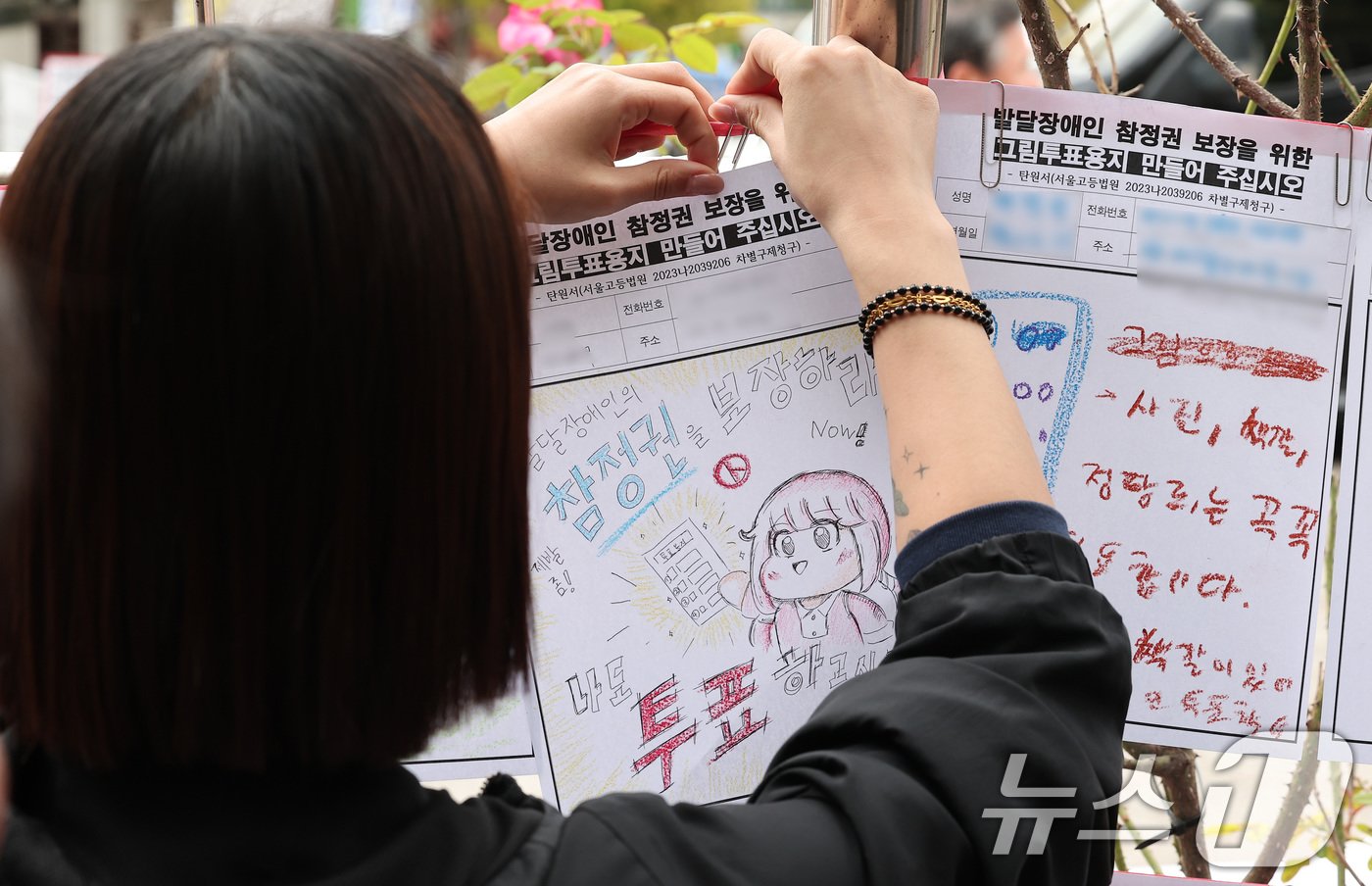 본문 이미지 - 한국피플퍼스트 회원들이 29일 오전 서울 서초구 서울중앙지방법원 앞에서 열린 발달장애인 그림투표용지 보장 차별구제소송 관련 기자회견에 앞서 그림 탄원서를 전시하고 있다. 2024.10.29/뉴스1 ⓒ News1 김성진 기자