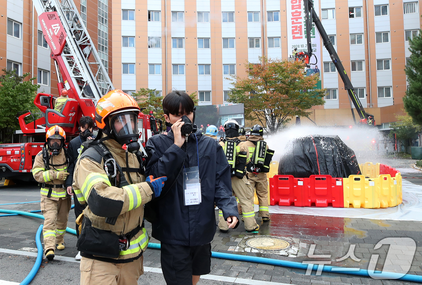 (서울=뉴스1) 오대일 기자 = 29일 서울 송파구 한국체육대학교 생활관에서 열린 2024 송파구 재난대응 안전한국훈련에서 소방관들이 전기차 화재 상황을 가정해 인명 구조 및 화재 …