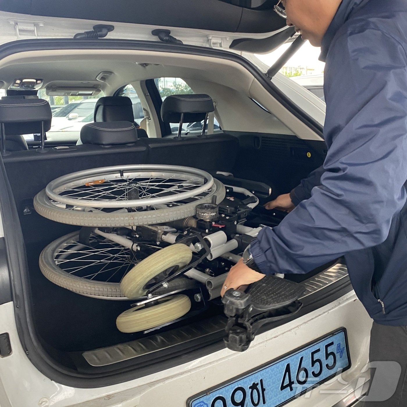 본문 이미지 -  SK렌터카 제주지점에서 차량 대여 시 무료로 대여 가능한 수전동 휠체어를 직원이 차량에 싣고 있는 모습(SK렌터카 제공)