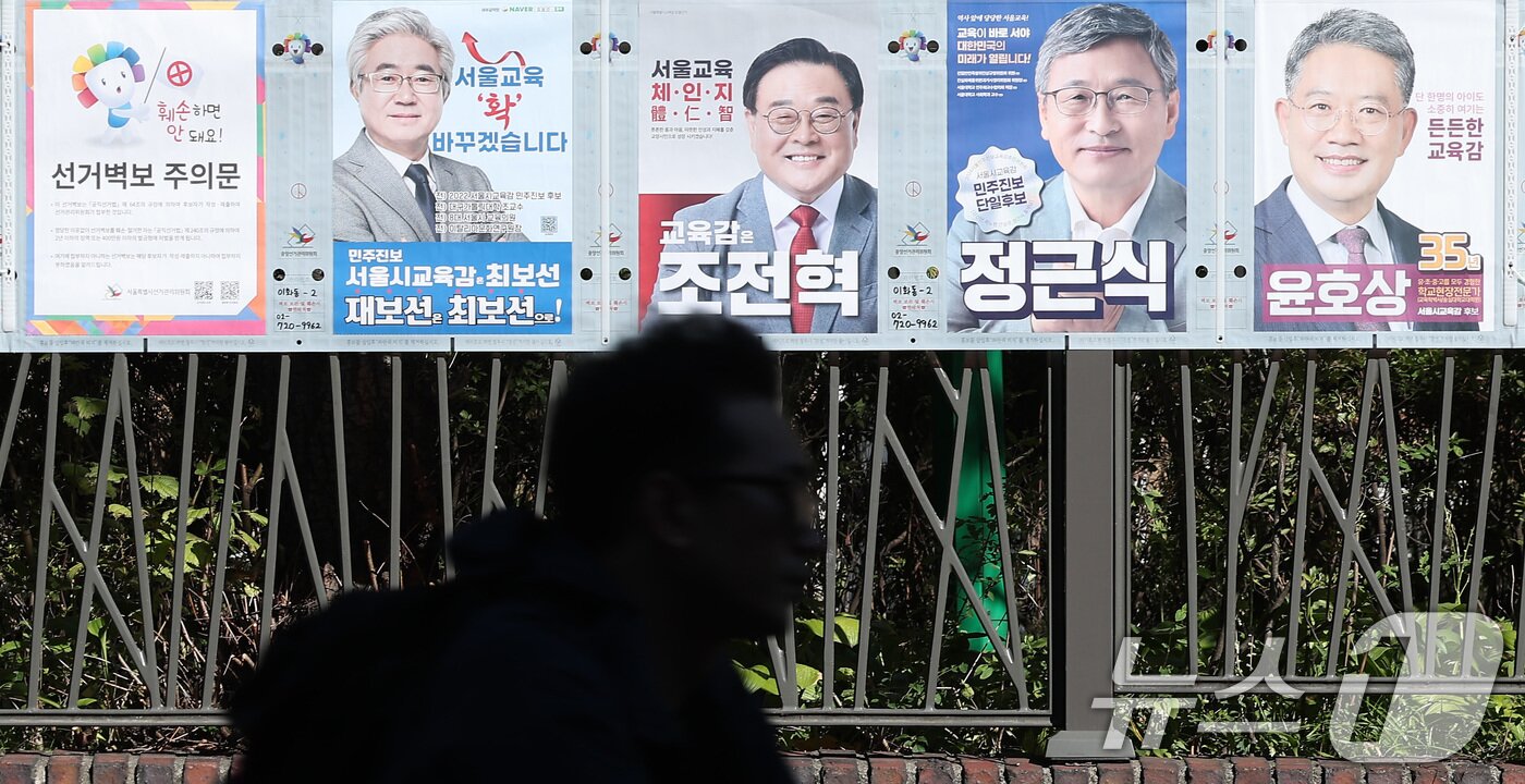 본문 이미지 - 한 시민이 2024년 10월 16일 실시된 서울시교육감 보궐선거 벽보 앞을 지나고 있다. (뉴스1DB) ⓒ 뉴스1 김성진 기자