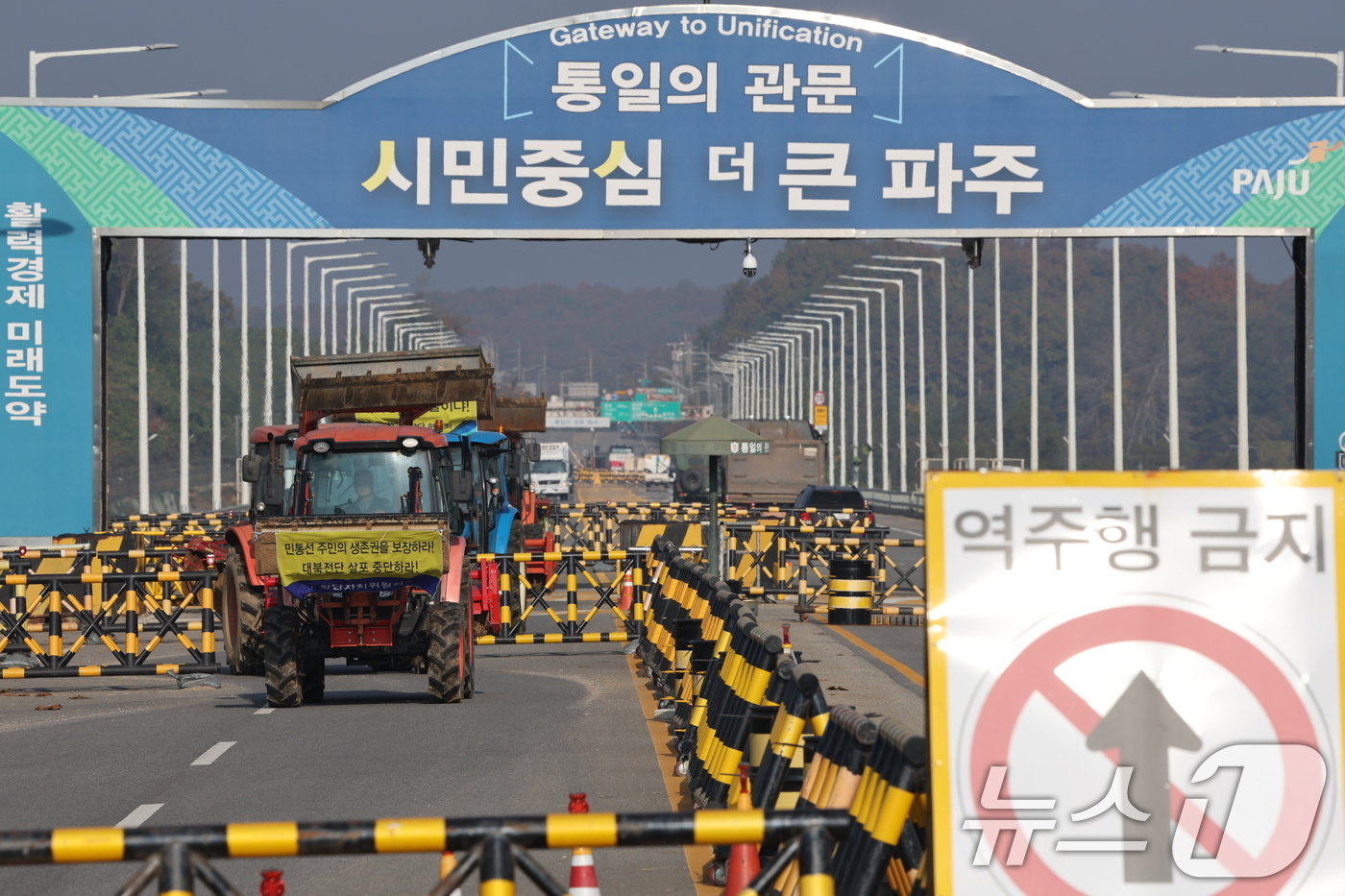 본문 이미지 - 파주 접경지역 주민 등이 31일 오전 경기도 파주시 임진각 내 6·25전쟁납북자기념관 앞에서 납북자피해가족협의회 주최로 열리는 대북 전단 살포 행사를 저지하기 위해 트랙터를 이끌고 통일대교에서 나오고 있다. 2024.10.31/뉴스1 ⓒ News1 이재명 기자