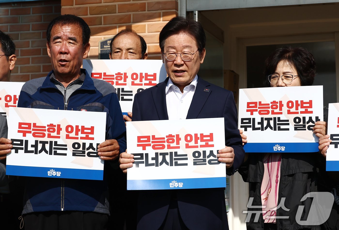 본문 이미지 - 더불어민주당 이재명 대표를 비롯한 소속 의원들이 31일 오전 북한의 대남방송으로 소음 피해를 보고 있는 인천 강화군 당산리마을을 방문 마을 주민과 간담회를 마친 후 '무능한 안보, 무너지는 일상'이라고 적힌 손피켓을 들고 구호를 외치고 있다. 2024.10.31/뉴스1 ⓒ News1 김민지 기자