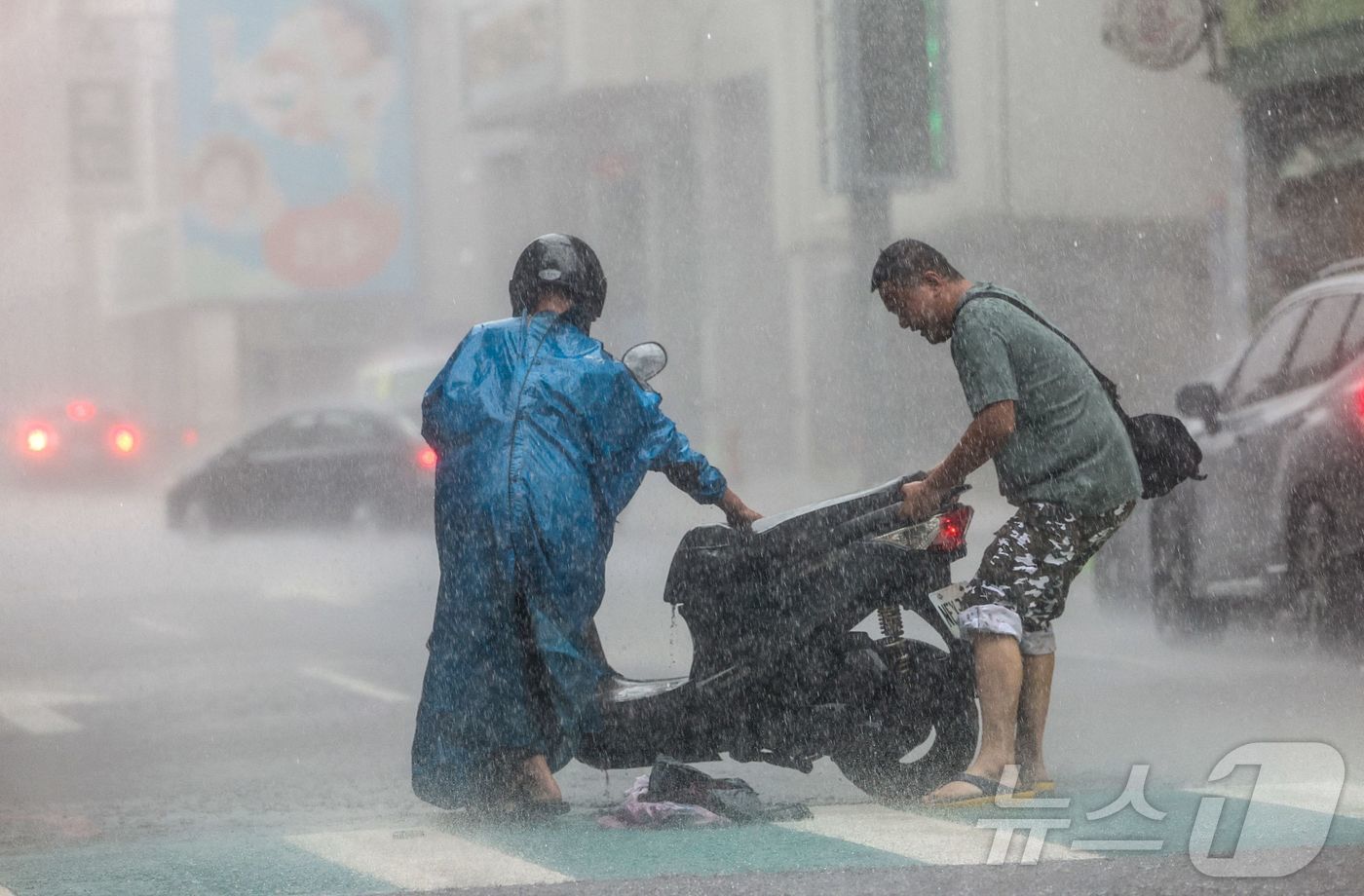 (지룽시 AFP=뉴스1) 김지완 기자 = 31일 태풍 '콩레이'가 접근중인 대만 북부 지룽시에서 폭우가 내리고 있는 가운데 남성 2명이 넘어진 오토바이를 일으켜 세우고 있다. 20 …