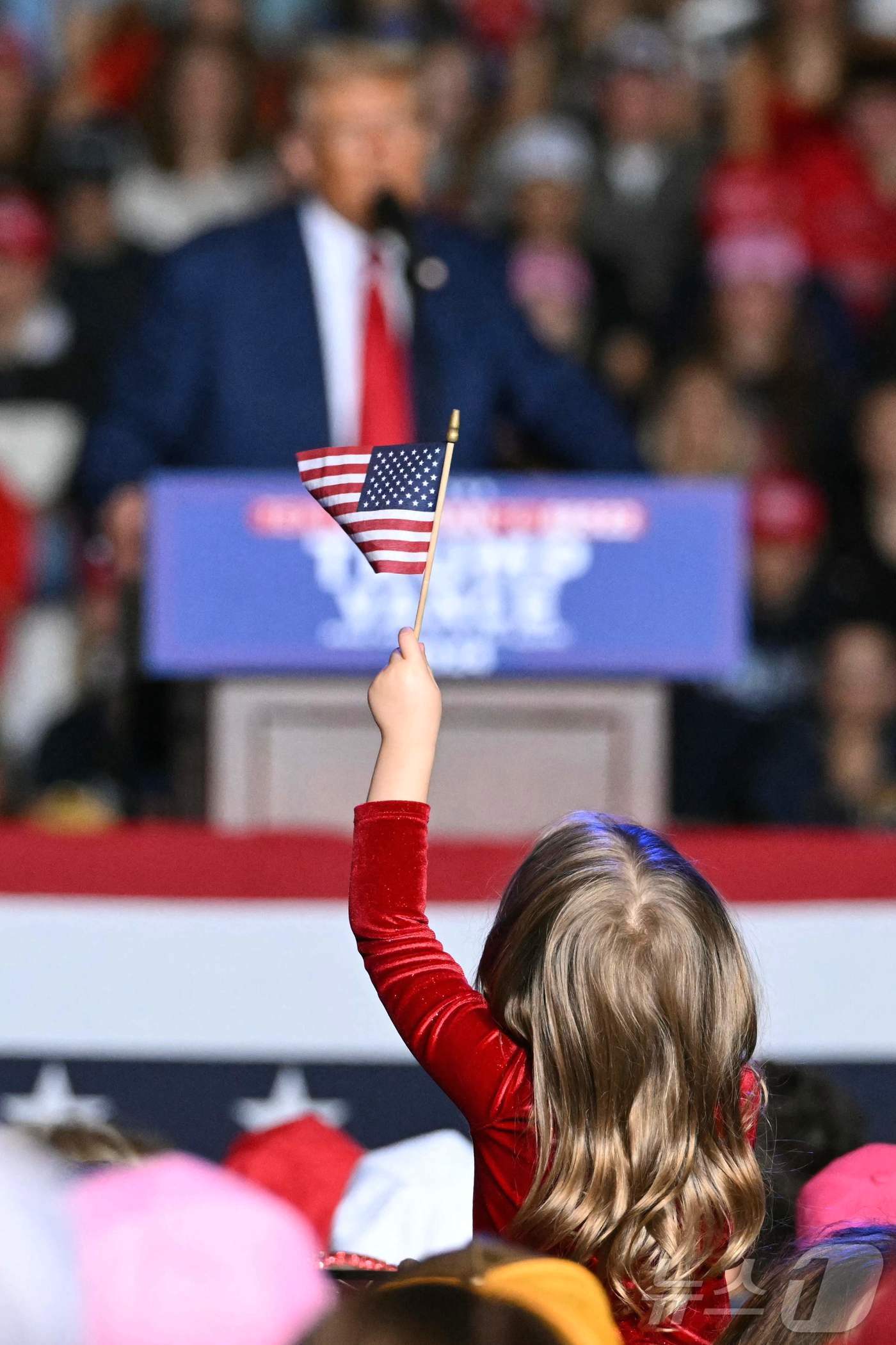 본문 이미지 - 미국 공화당 대통령 후보 도널드 트럼프 전 대통령이 지난 3일(현지시간) 미시간주 새기노에서 가진 선거 유세 중 어린이가 성조기를 흔들고 있다. 2024.10.04 ⓒ AFP=뉴스1 ⓒ News1 우동명 기자