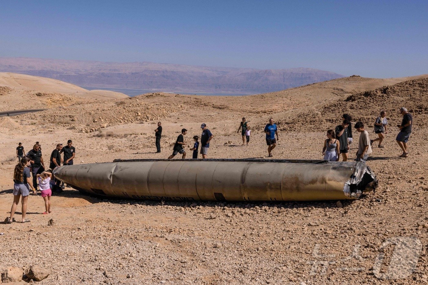 본문 이미지 - 3일(현지시간) 사람들이 이스라엘 남부 아라드의 네게브 사막에 떨어진 이란 미사일 잔해를 구경하고 있다. 2024.10.03 ⓒ AFP=뉴스1 ⓒ News1 김지완 기자