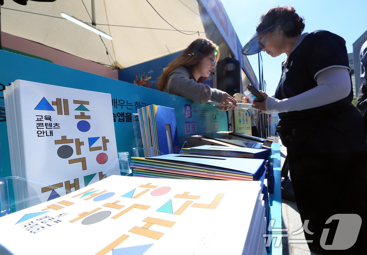 본문 이미지 - 578돌 한글날을 기념해 '괜찮아?! 한글'을 주제로 '2024 한글주간'이 시작된 4일 낮 서울 광화문광장에 마련된 전시·체험 행사장을 찾은 시민들이 세종학당재단의 교육 콘텐츠를 안내 받고 있다. 2024.10.4/뉴스1 ⓒ News1 박정호 기자