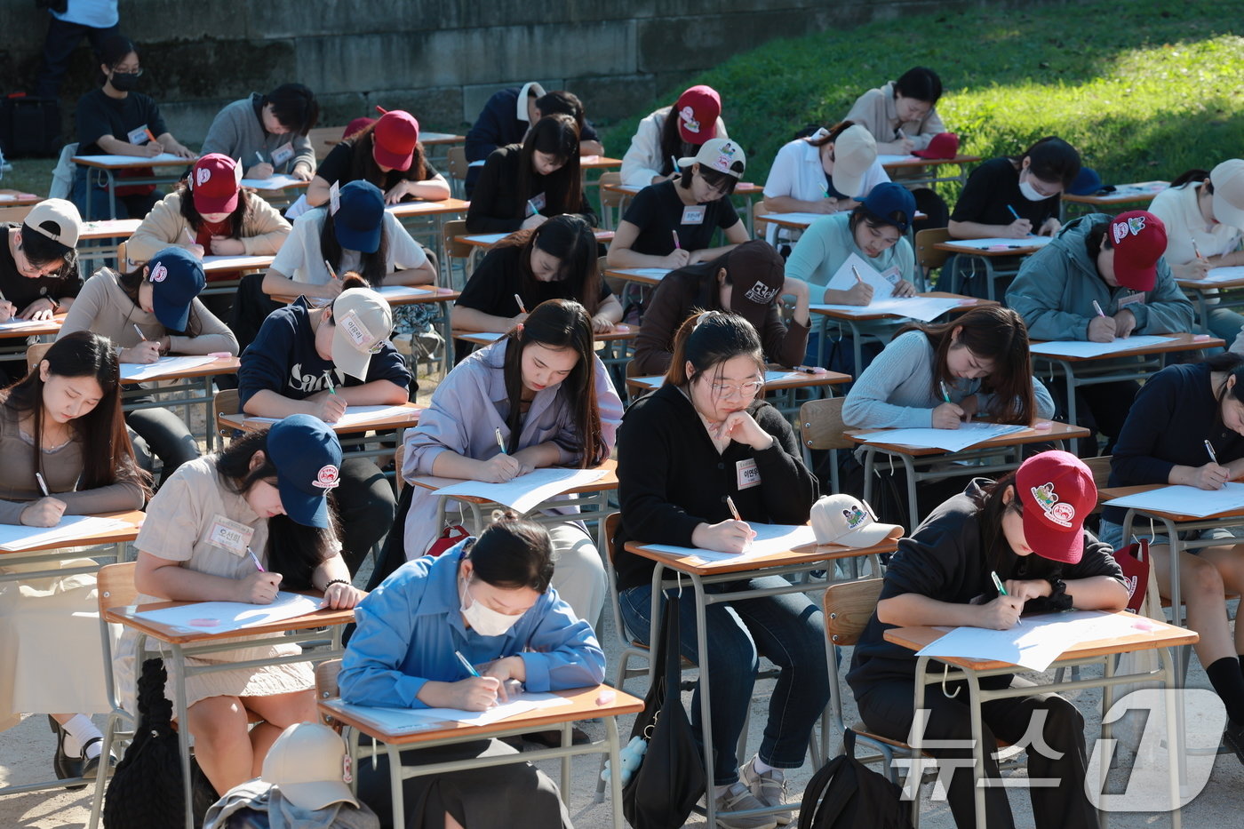 본문 이미지 - 578돌 한글날을 기념해 '괜찮아?! 한글'을 주제로 '2024 한글주간'이 시작된 4일 오후 서울 종로구 경복궁 흥복전에서 열린 '전 국민 받아쓰기 대회‘에서 참가자들이 진지하게 문제를 들은 뒤 받아 적고 있다.2024.10.4/뉴스1 ⓒ News1 박정호 기자