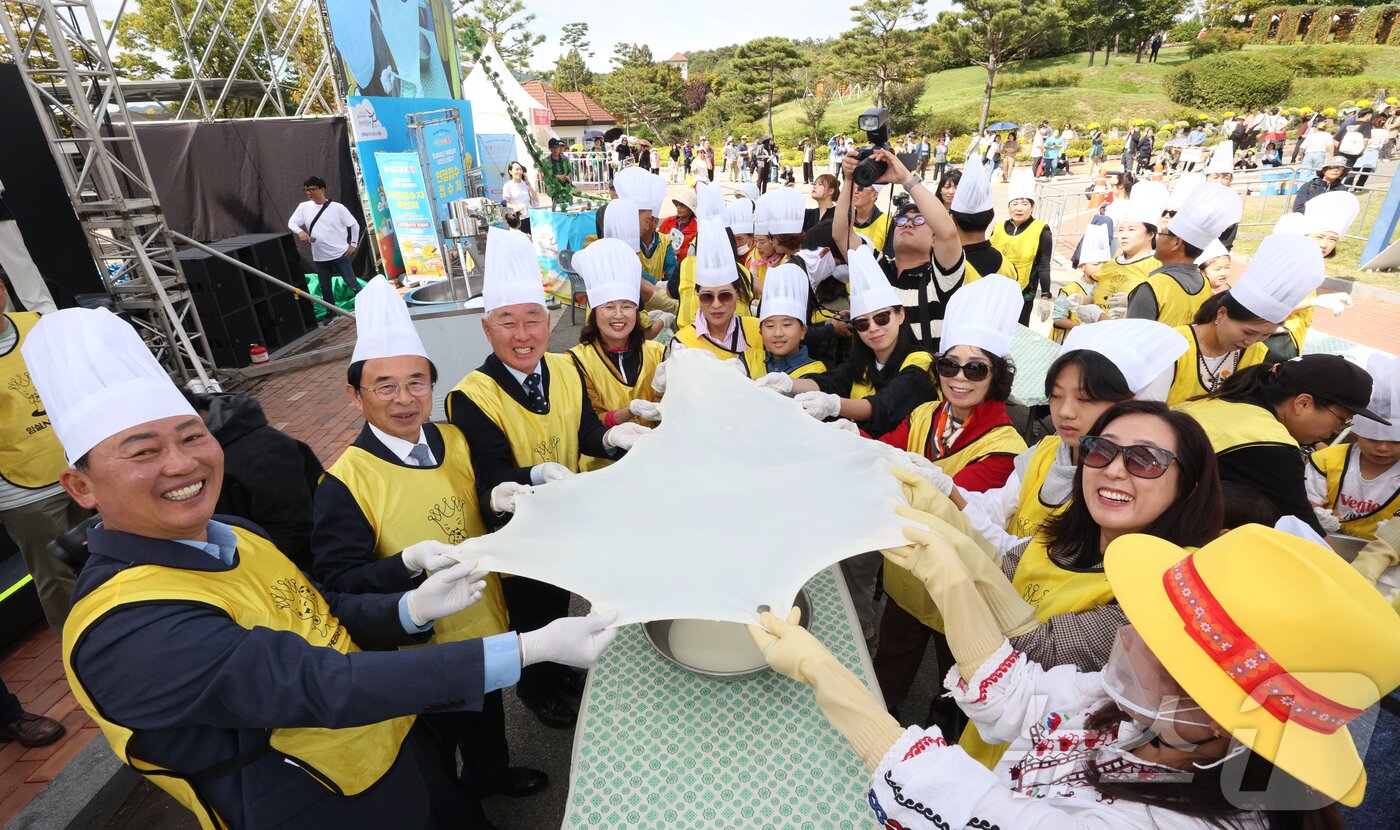 본문 이미지 - 5일 전북자치도 임실군에서 치즈축제가 열리고 있는 가운데 심민 군수 등이 치즈 늘리기에 참여하고 있다.&#40;임실군제공&#41;2024.10.5/뉴스1 ⓒ News1 김동규 기자