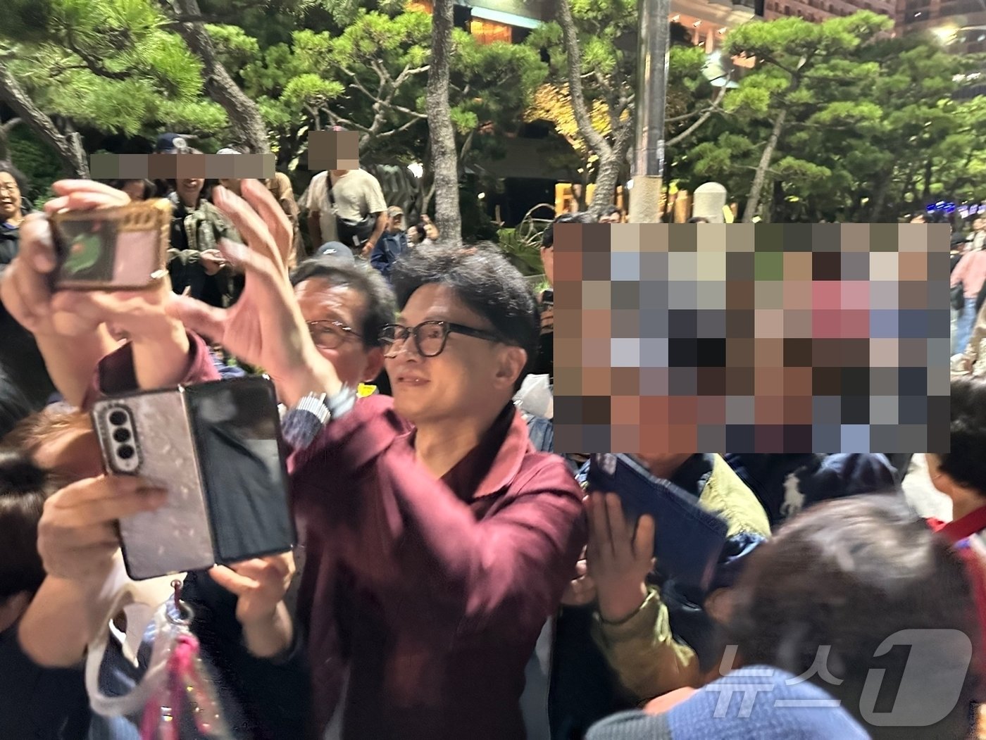 본문 이미지 - 한동훈 국민의힘 대표가 5일 밤 부산 해운대해수욕장에서 시민들과 사진 촬영을 하고 있다. (독자 사진 제공)