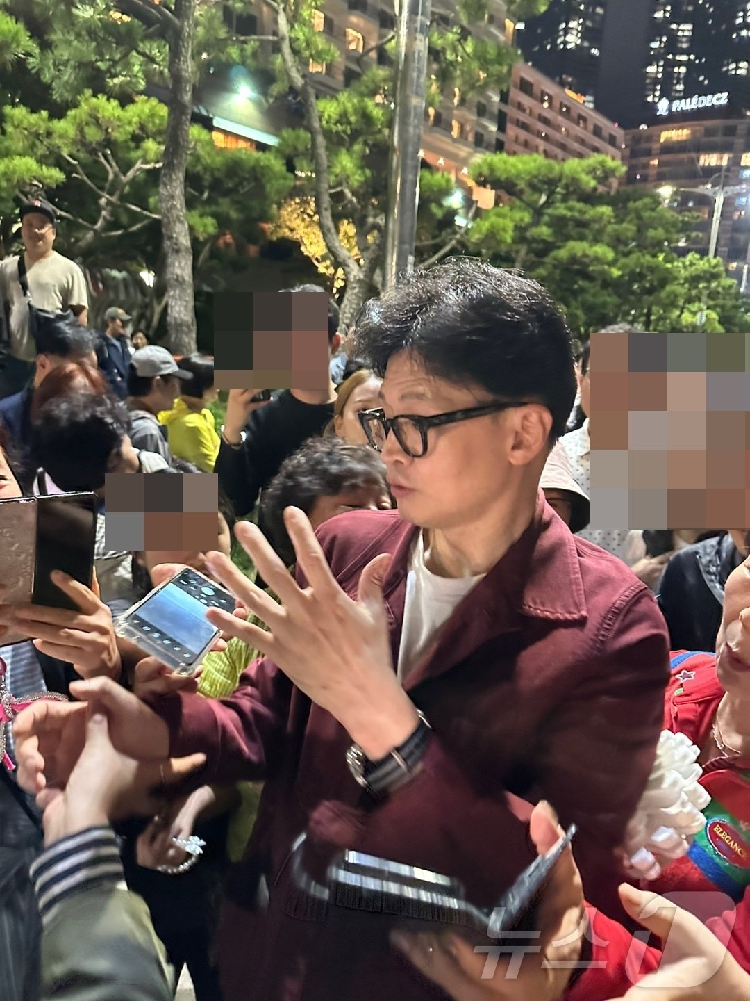 본문 이미지 - 한동훈 국민의힘 대표가 5일 밤 부산 해운대해수욕장에서 시민들과 사진 촬영을 하고 있다. (독자 사진 제공)