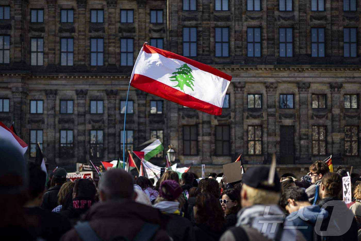 본문 이미지 - 5일(현지시간) 네덜란드 수도 암스테르담에서 열린 팔레스타인 지지 시위에서 한 참가자가 이스라엘의 공격을 받고 있는 레바논 국기를 들고 있다. 2024.10.05 ⓒ AFP=뉴스1 ⓒ News1 김지완 기자