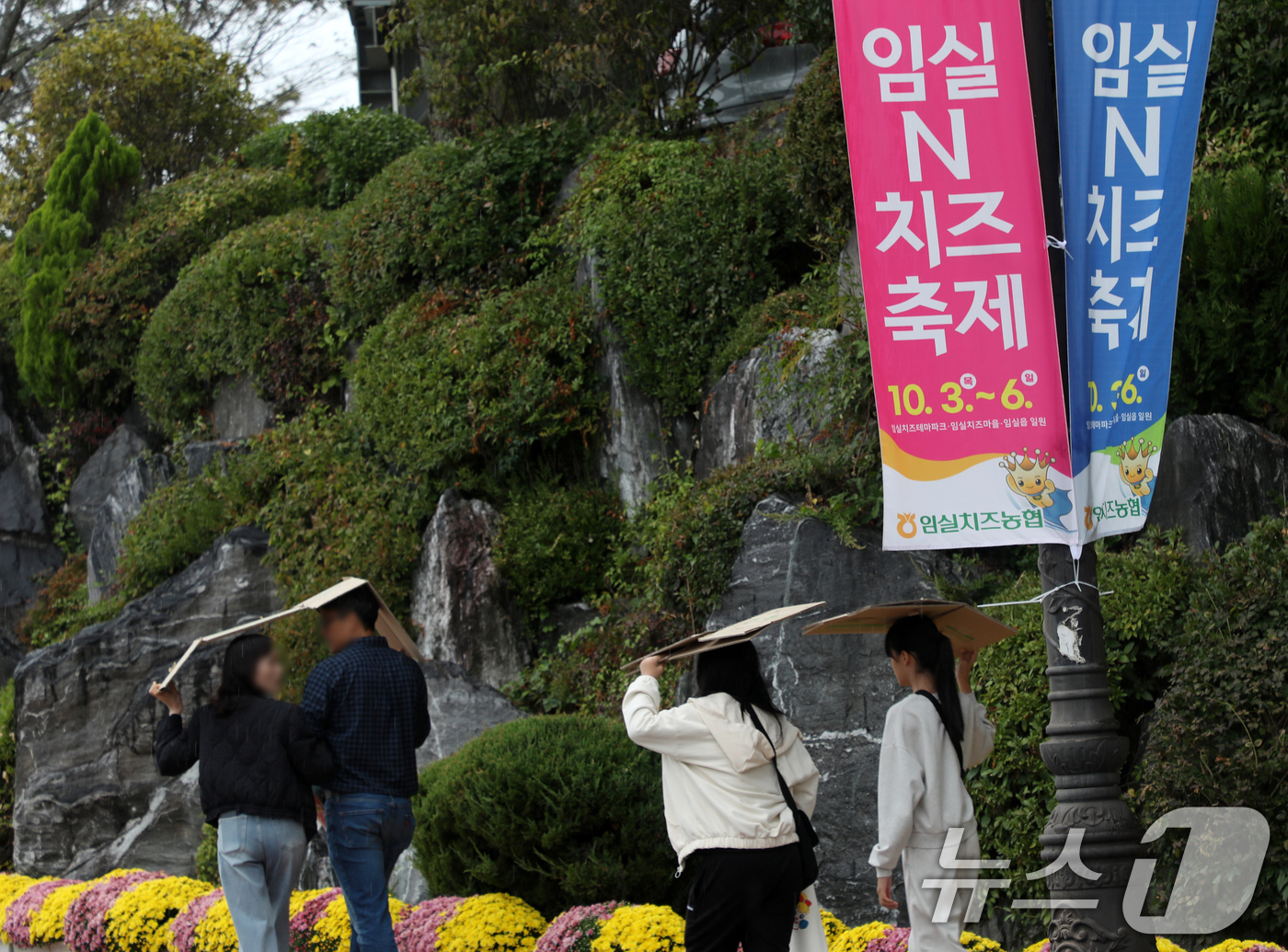 (임실=뉴스1) 유경석 기자 = 임실N치즈축제 마지막날인 6일 전북자치도 임실군 치즈테마파크에서 방문객들이 빗방울이 떨어지자 박스로 비를 막으며 발걸음을 재촉하고 있다. 2024. …