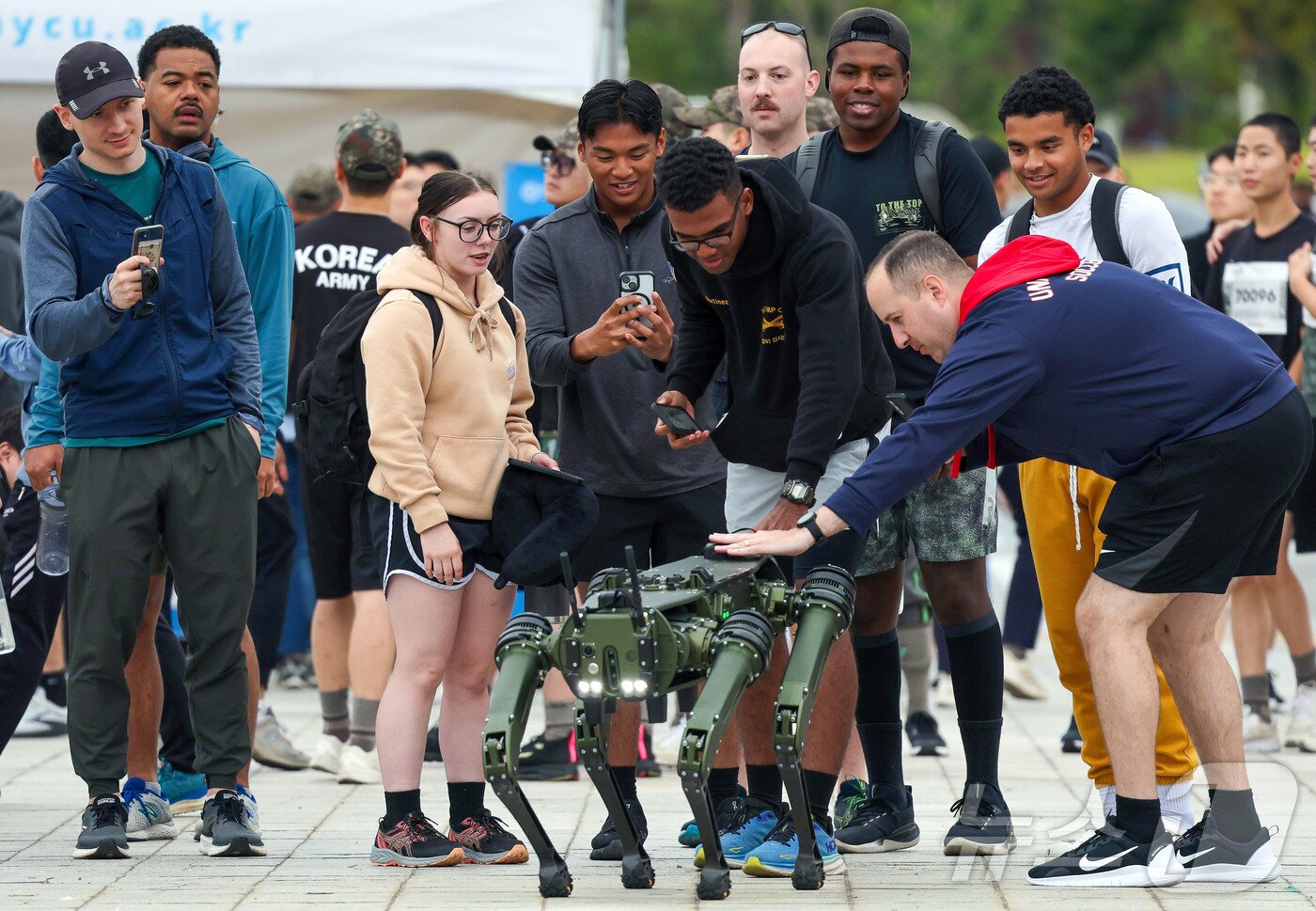 본문 이미지 - 지난 2024년 '건군 76주년 기념 제20회 전우마라톤 대회'를 찾은 주한미군 장병들이 사족보행 로봇을 살펴보는 모습. 2024.10.6 ⓒ 뉴스1 박지혜 기자 (국방일보 제공)