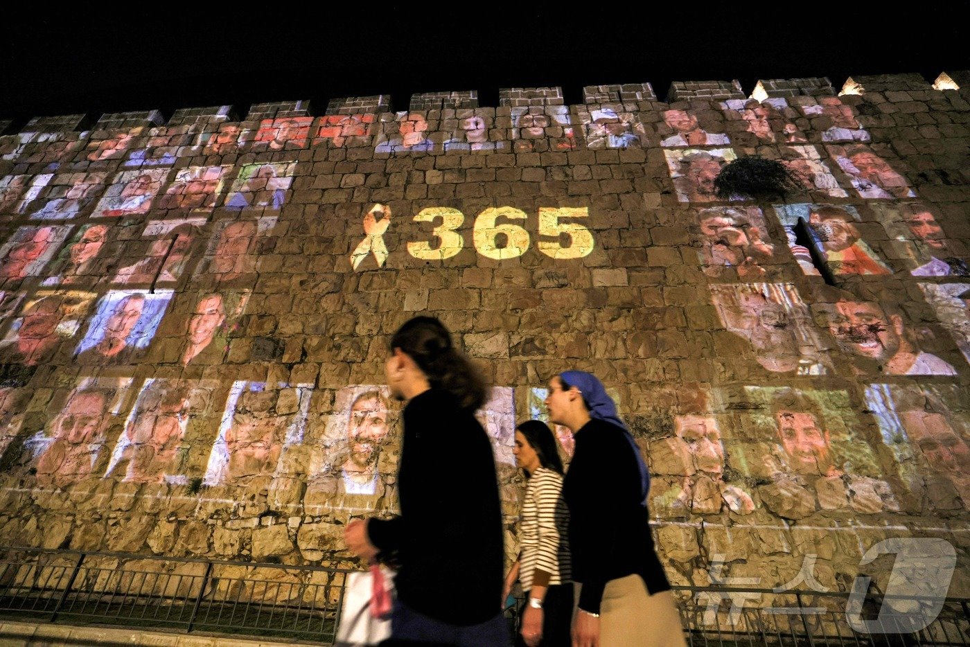 본문 이미지 - 팔레스타인 무장정파 하마스의 이스라엘 공격으로 촉발된 가자지구 전쟁이 1주년을 맞기 하루 전날인 6일(현지시간) 이스라엘 예루살렘 성벽에 희생자들을 기리는 사진이 그들을 기리는 노란 리본과 함께 떠 있다. 숫자 365는 1년을 의미하는 것이다. 2024.10.06. ⓒ AFP=뉴스1 ⓒ News1 조소영 기자