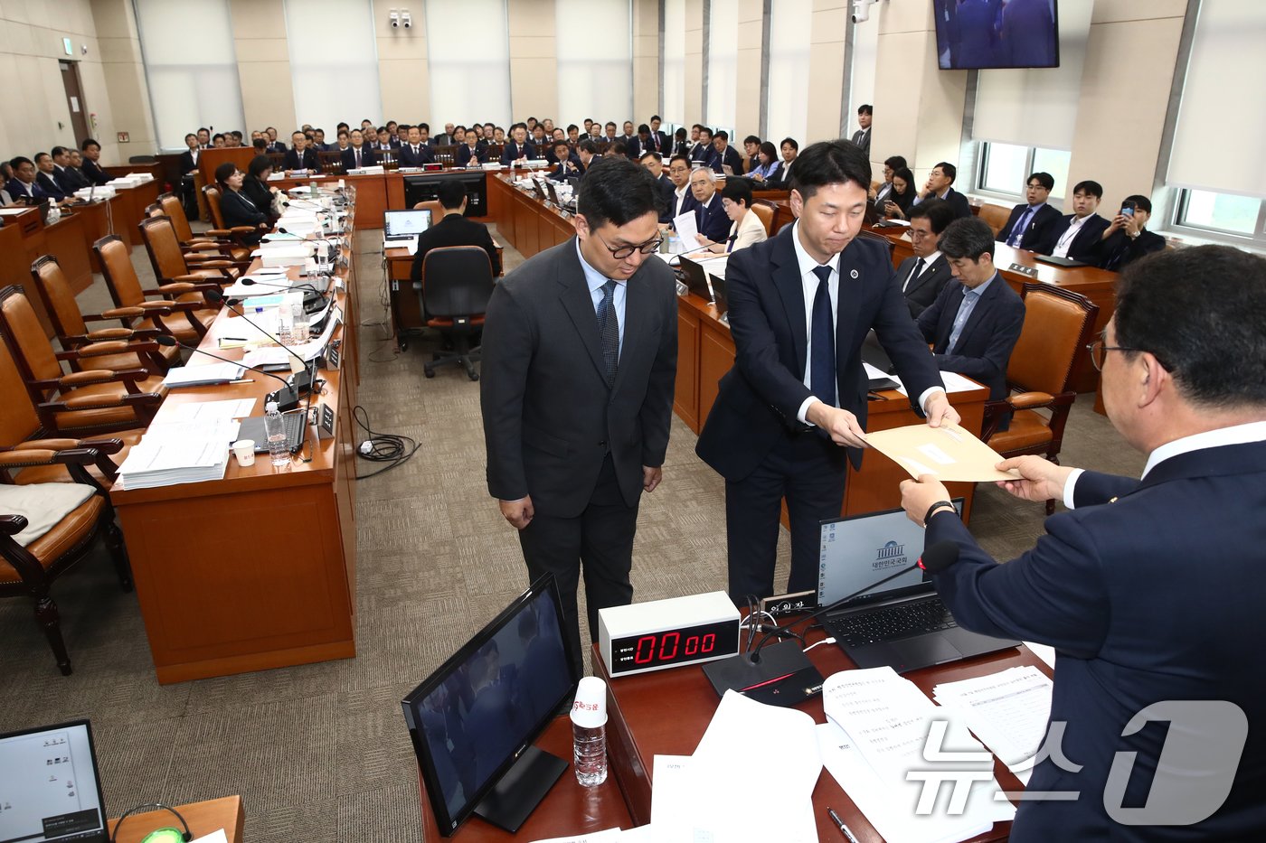 신정훈 국회 행안위원장이 7일 오전 서울 여의도 국회 행정안전위원회 전체회의장에서 열린 행정안전부 등에 대한 국정감사에서 불출석 사유서를 제출하지 않고 국감 출석을 회피한 &#39;대통령 관저 증축&#39; 의혹 증인인 21그램 김태영, 이승만 대표에 대한 동행명령장을 경위들에게 전달하고 있다. 이날 여당 의원들은 동행명령장 발부에 항의하며 국감장을 나갔다.2024.10.7/뉴스1 ⓒ News1 이광호 기자