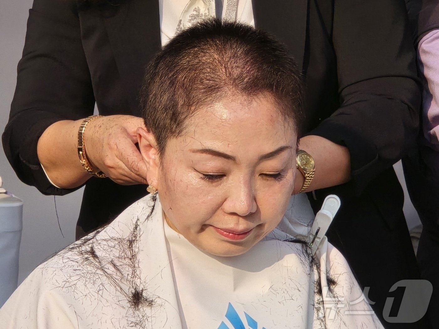 본문 이미지 - 8일 오후 세종시청에 설치된 최민호 시장 단식 천막 앞에서 홍나영 국민의힘 세종시의원이 눈을 감은 채 삭발을 하고 있다. 이날 국민의힘 소속 시의원 7명이 모두 삭발했다. 홍 의원은 유일한 여성의원이다. 2024.10.8/뉴스1 ⓒ News1 장동열 기자