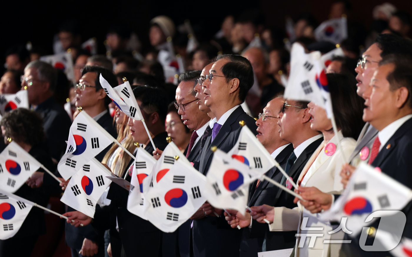 (서울=뉴스1) 황기선 기자 = 한덕수 국무총리가 9일 오전 서울 종로구 세종문화회관에서 열린 '제578돌 한글날 경축식'에서 태극기를 들고 한글날 노래를 제창하고 있다. 2024 …