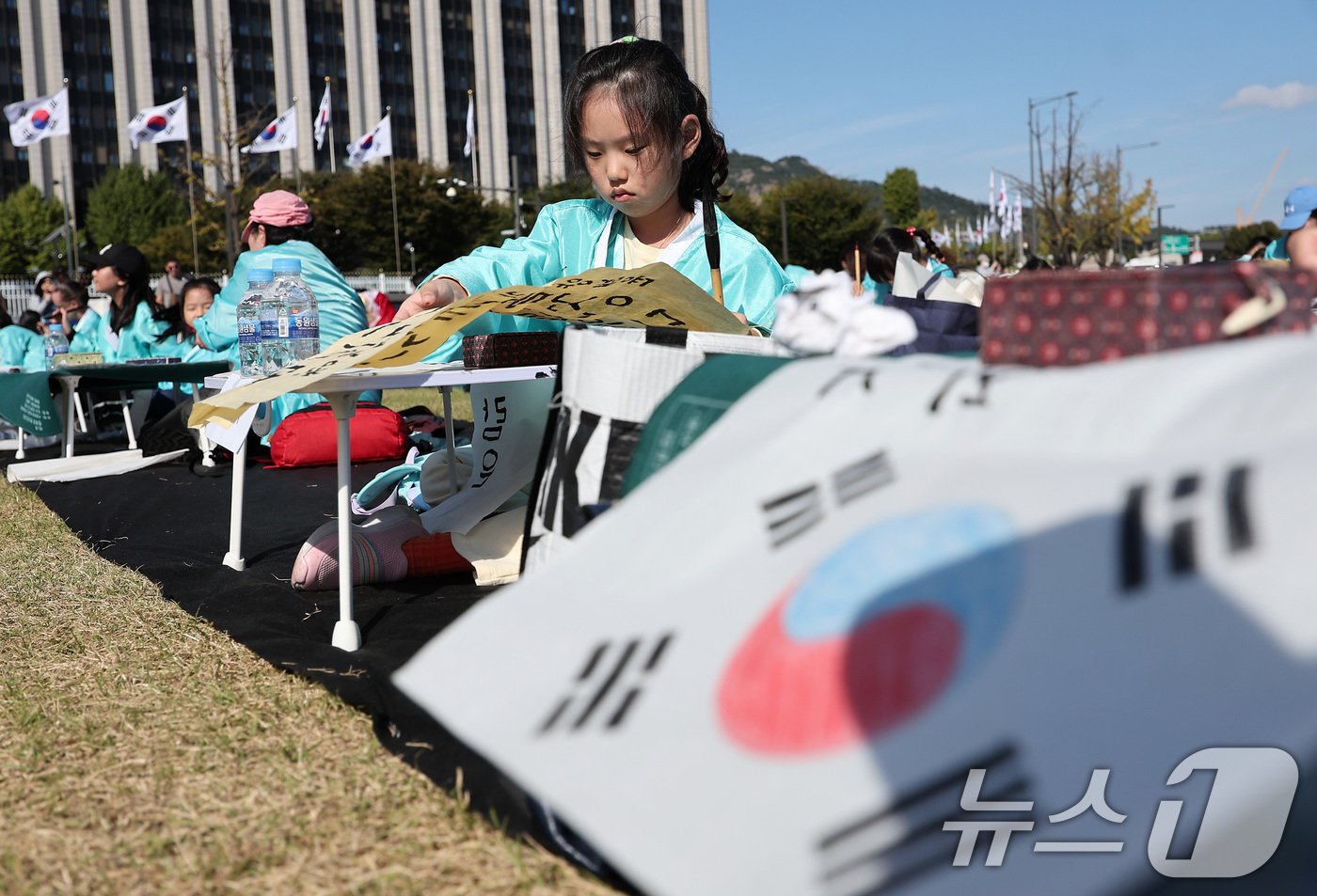 본문 이미지 - 제578돌 한글날을 맞은 9일 오전 서울 종로구 광화문광장에서 한국예술문화원 주체로 열린 조선시대 과거 시험 재현 '휘호대회'에서 한 어린이 참가자가 글씨를 적고 있다. 2024.10.9/뉴스1 ⓒ News1 김성진 기자