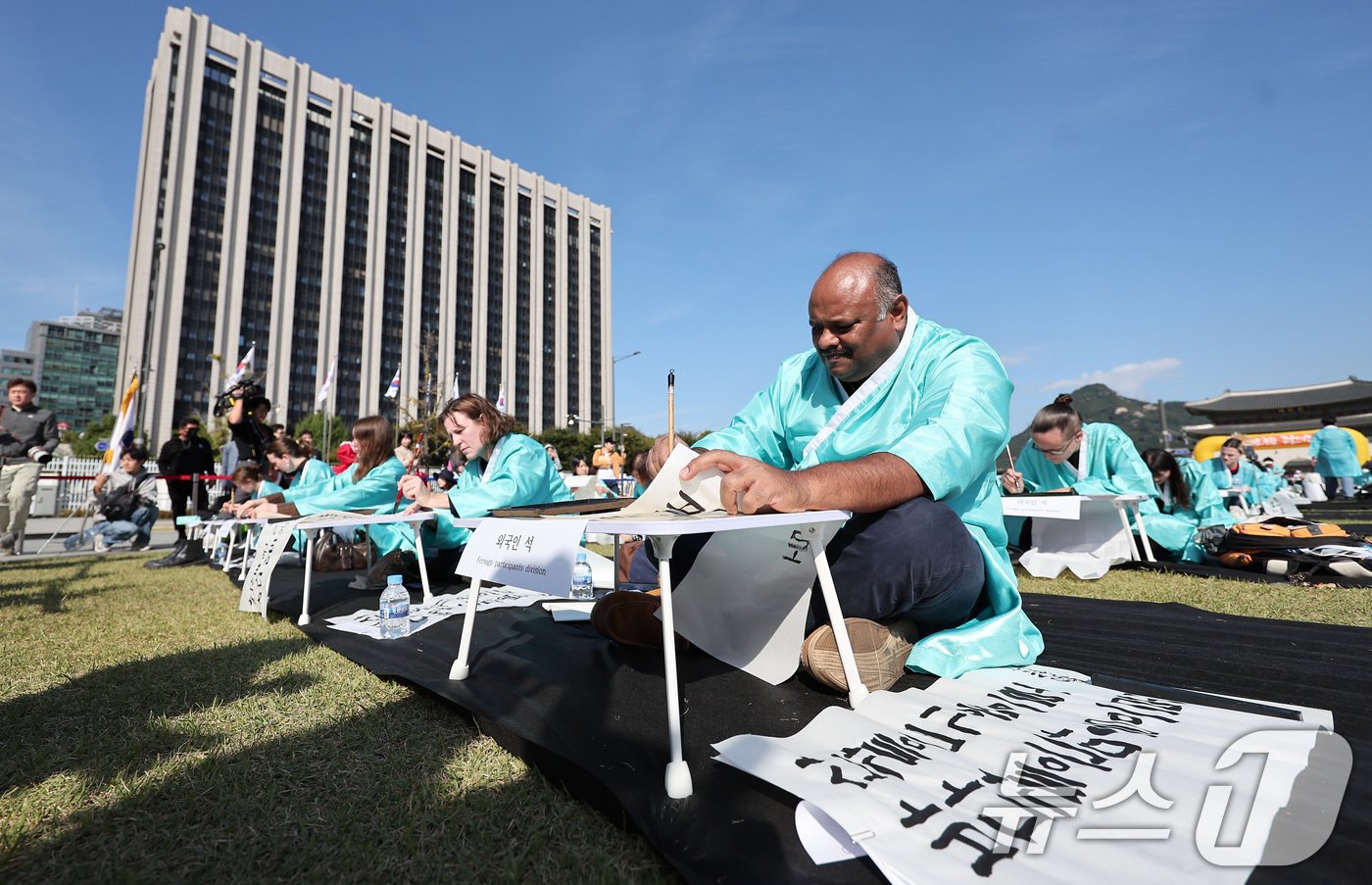 본문 이미지 - 제578돌 한글날을 맞은 9일 오전 서울 종로구 광화문광장에서 한국예술문화원 주체로 열린 조선시대 과거 시험 재현 '휘호대회'에서 외국인 참가자가 글씨를 적고 있다. 2024.10.9/뉴스1 ⓒ News1 김성진 기자
