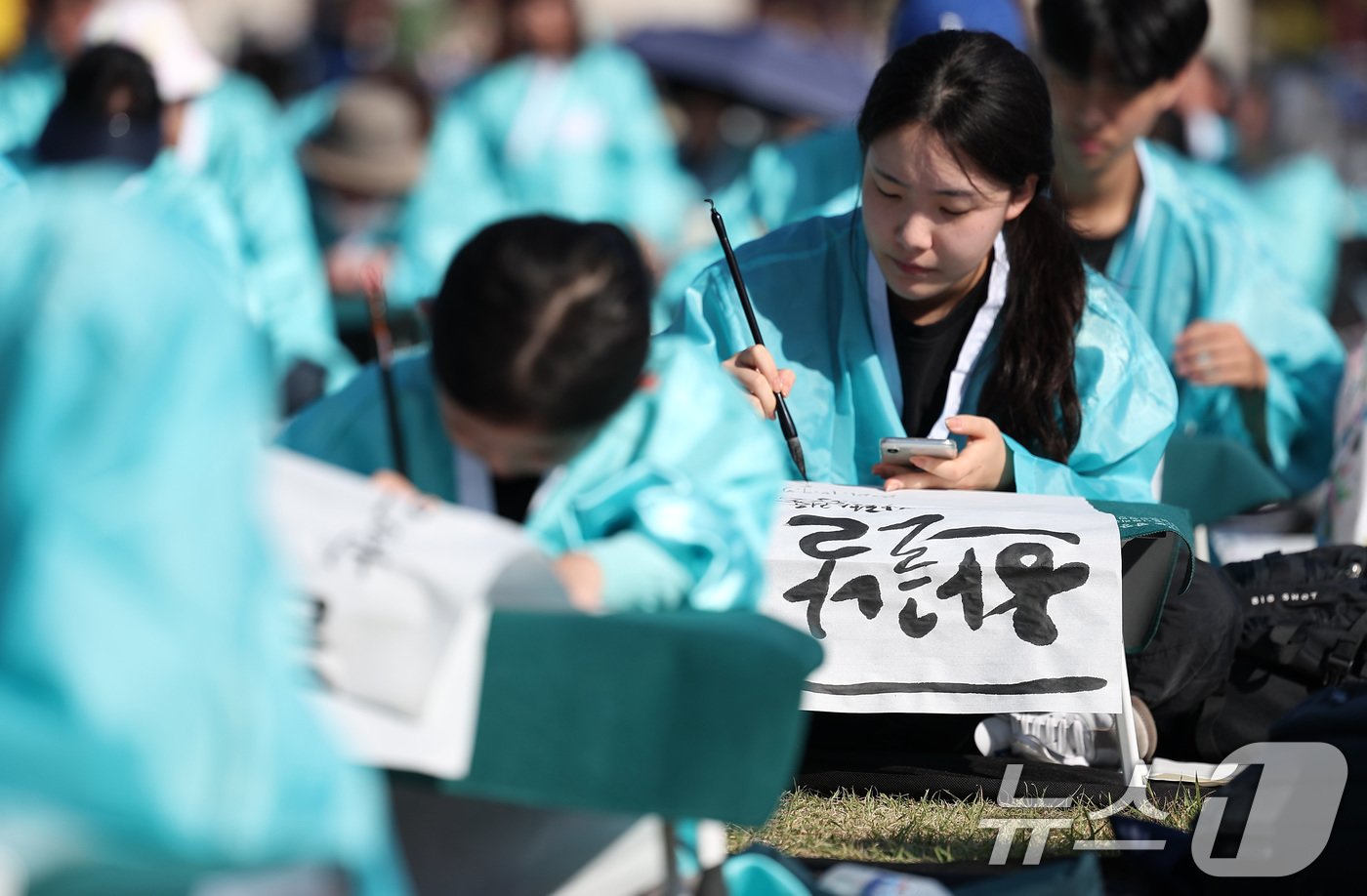 제578돌 한글날을 맞은 9일 오전 서울 종로구 광화문광장에서 한국예술문화원 주체로 열린 조선시대 과거 시험 재현 &#39;휘호대회&#39;에서 참가자 조이현&#40;16&#41; 양이 글씨를 쓰고 있다. 2024.10.9/뉴스1 ⓒ News1 김성진 기자